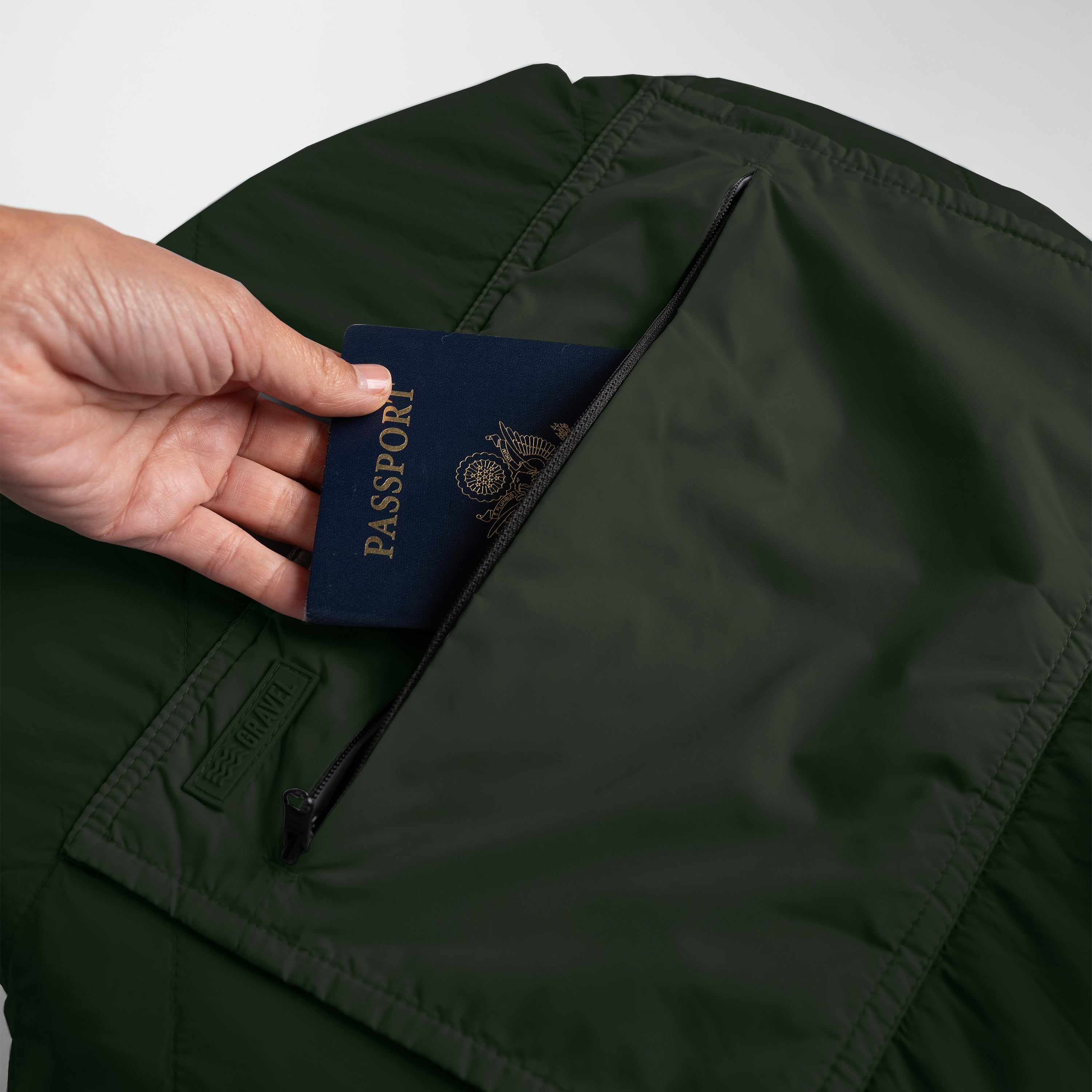 Gravel Layover™ Travel Blanket in Spruce color, shown folded with soft fabric and compact design, ideal for travel comfort.