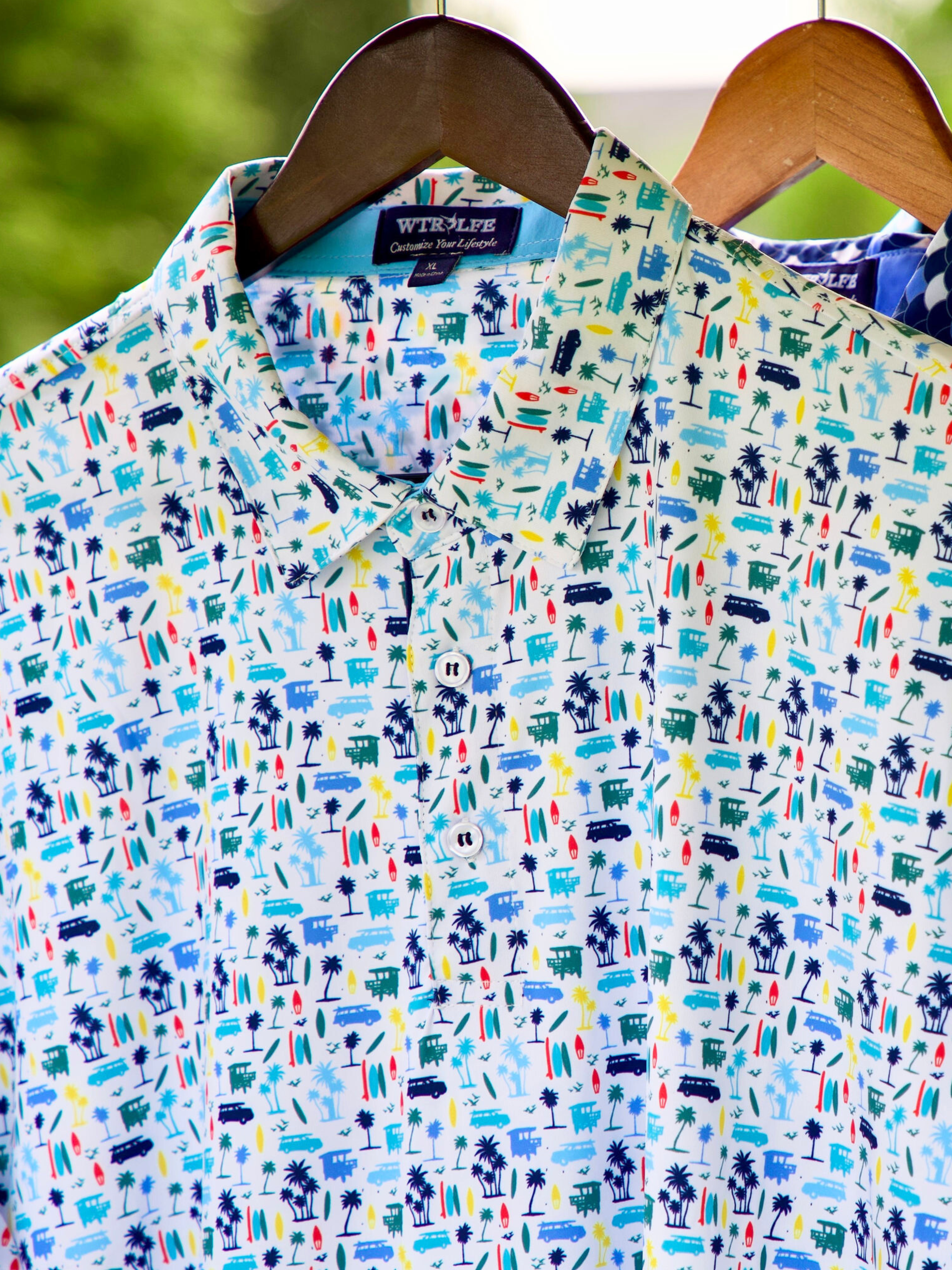White Water Life Surfs Up Polo hanging on a hanger, showcasing a casual men's polo shirt with surf-inspired design.