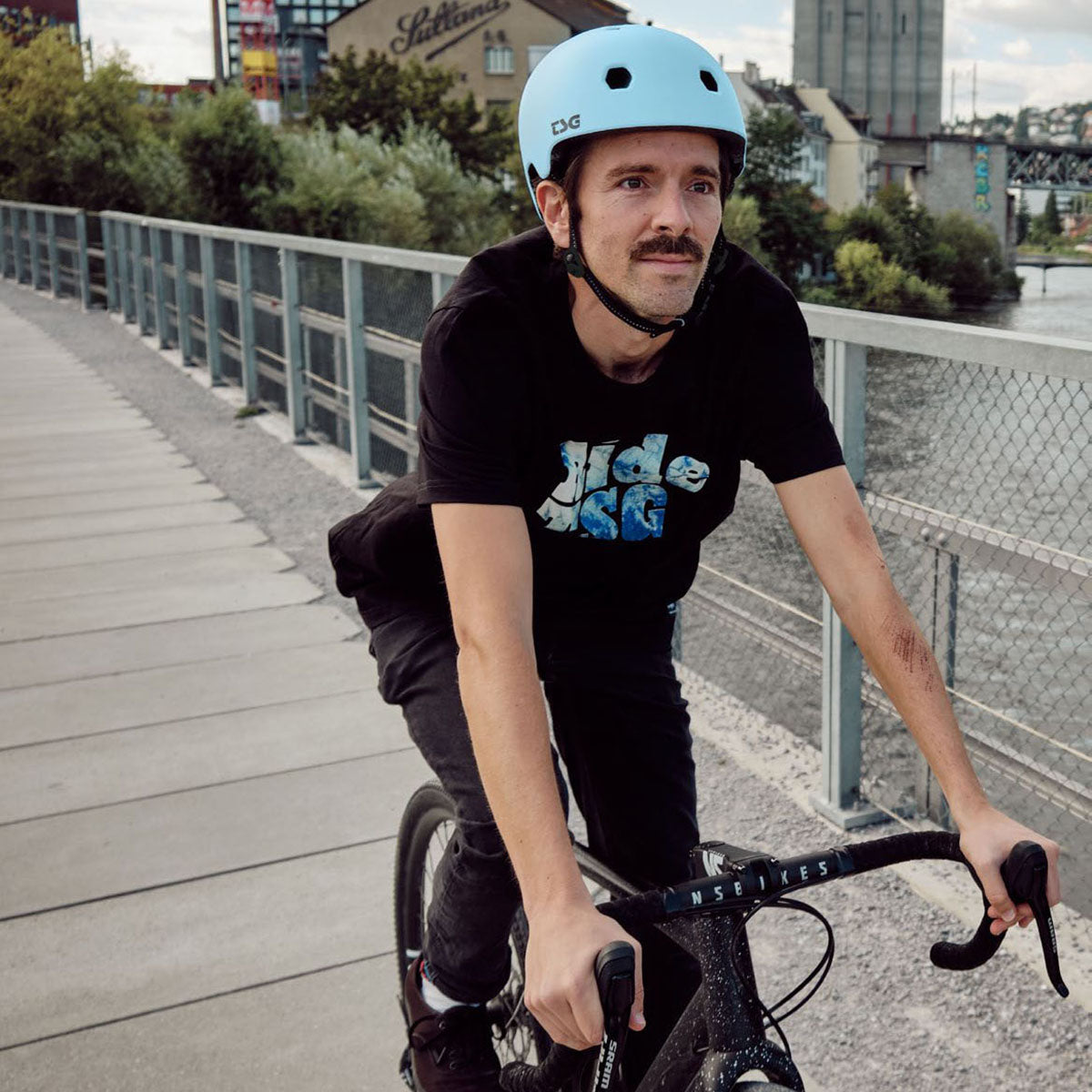 ZEITBIKE TSG Meta helmet in black with sleek ventilation design and adjustable straps, shown from the side.