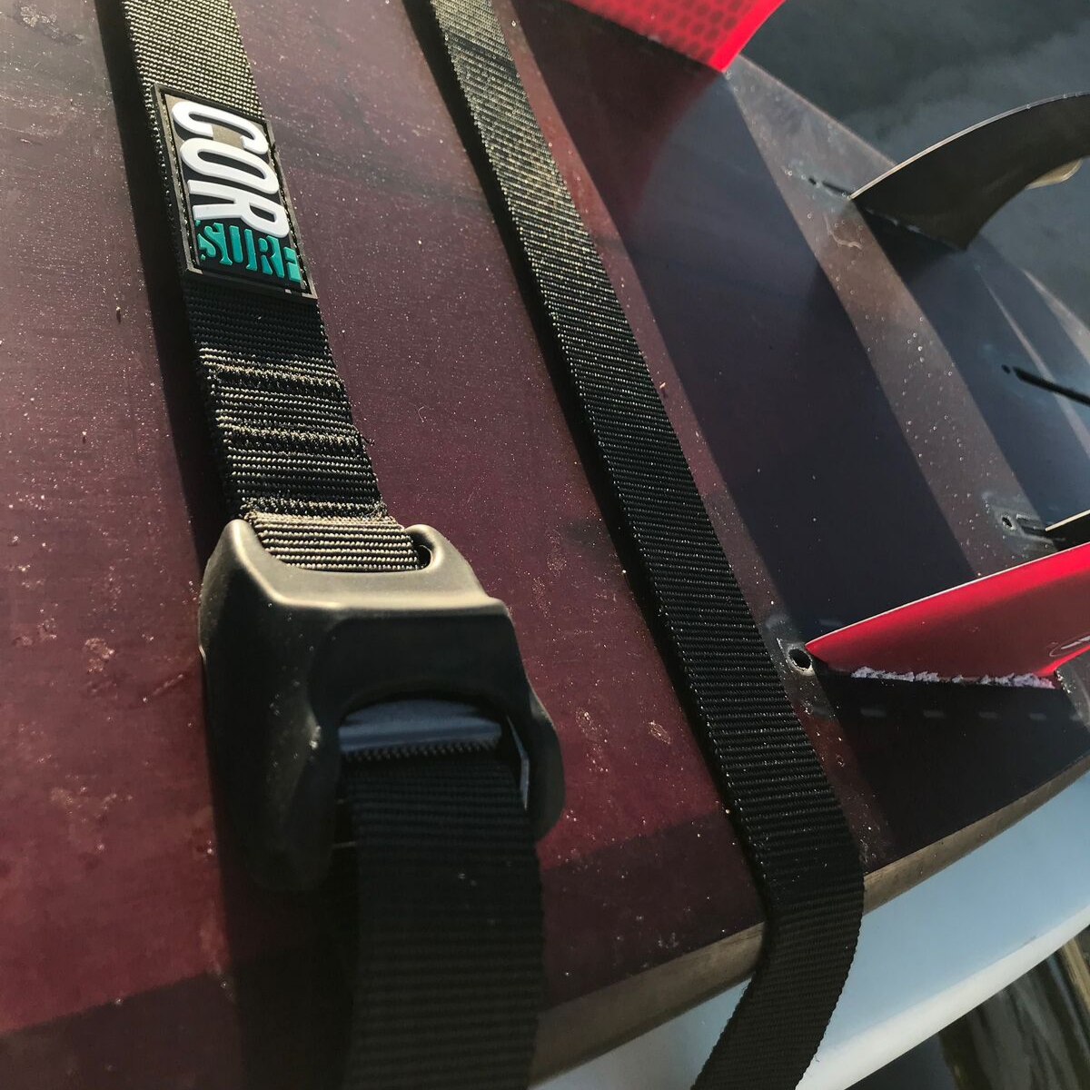 COR Surf scratch-resistant silicone tie down straps in 10 and 15 ft, shown secured for reliable cargo fastening.