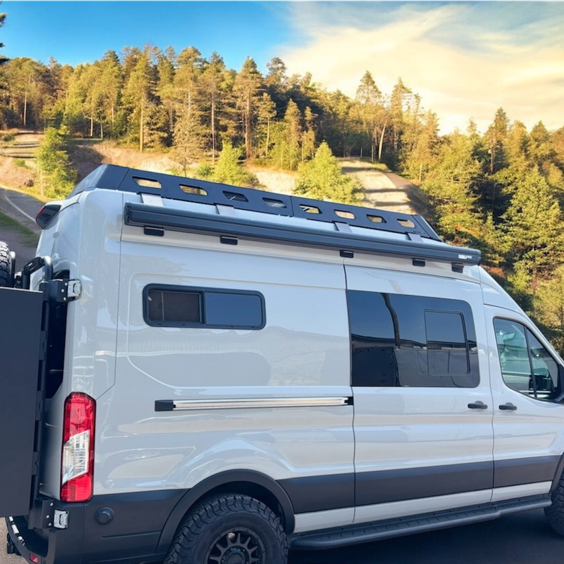 Ford Transit van with Avatar Offroad Rockbody side steps installed, showing close-up of durable, textured side step for easy access.