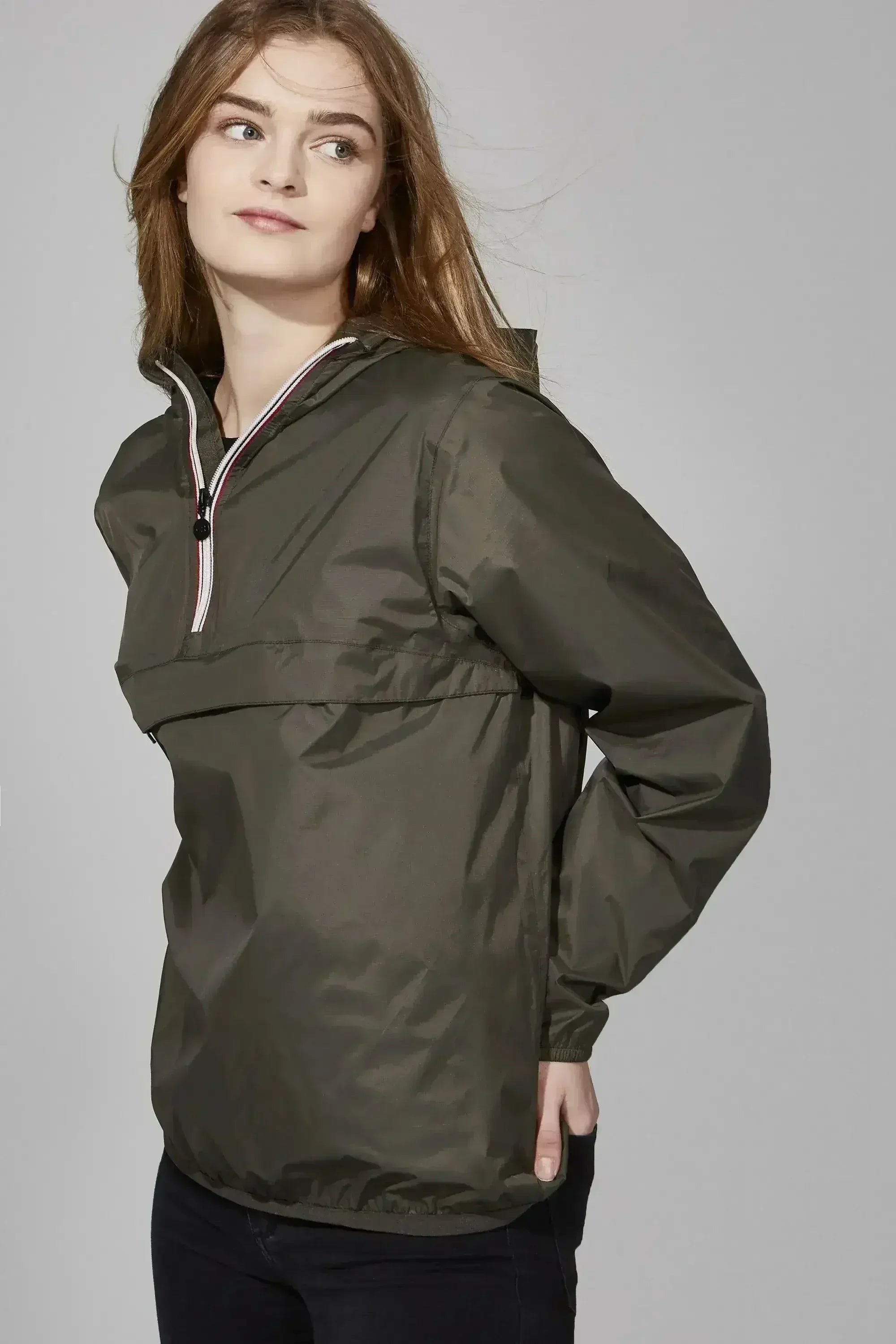 Femstylo Torba quarter zip packable rain jacket in light waterproof material, shown folded and partially zipped.