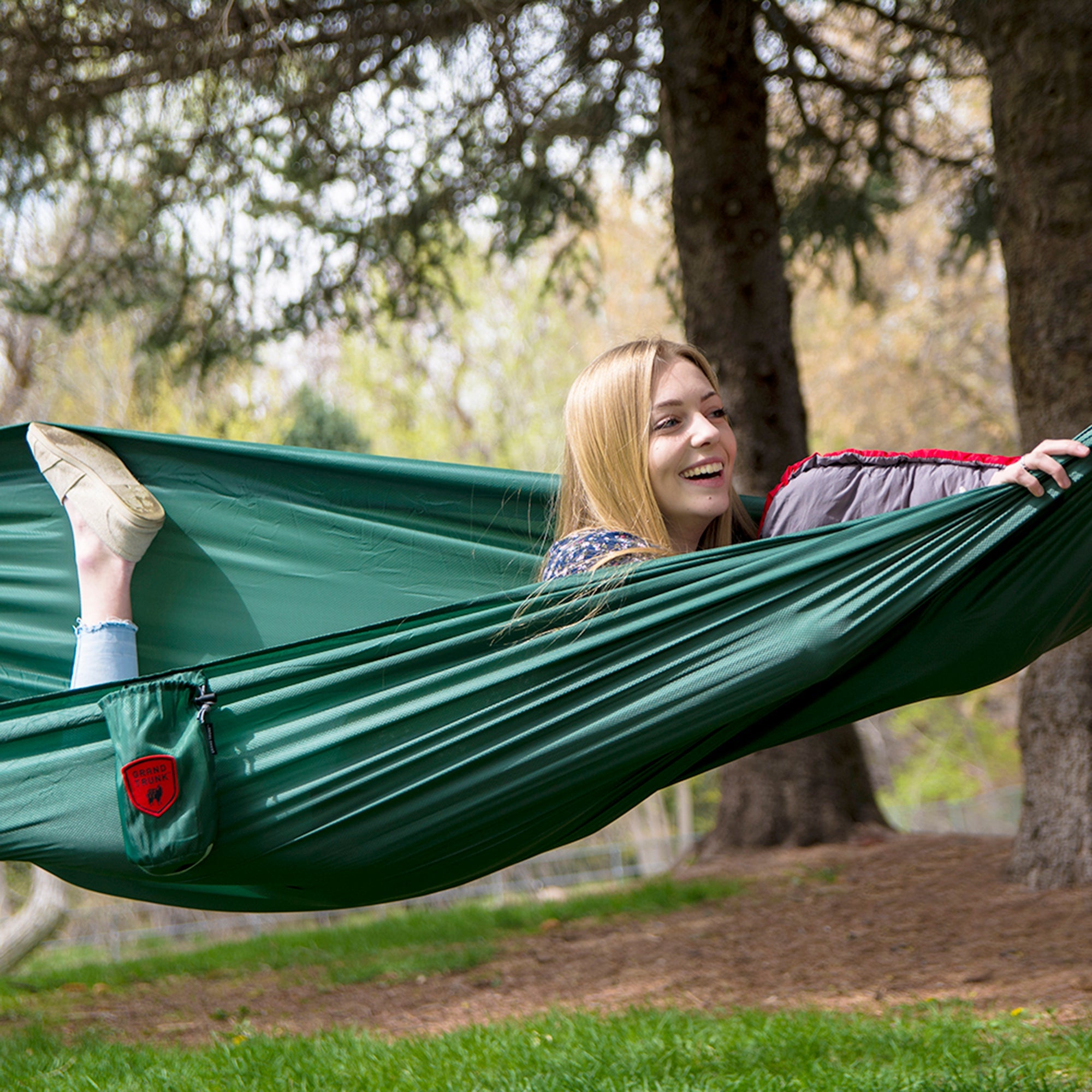 GrandTrunk ultralight starter hammock suspended between trees in an outdoor setting, showcasing its lightweight design.