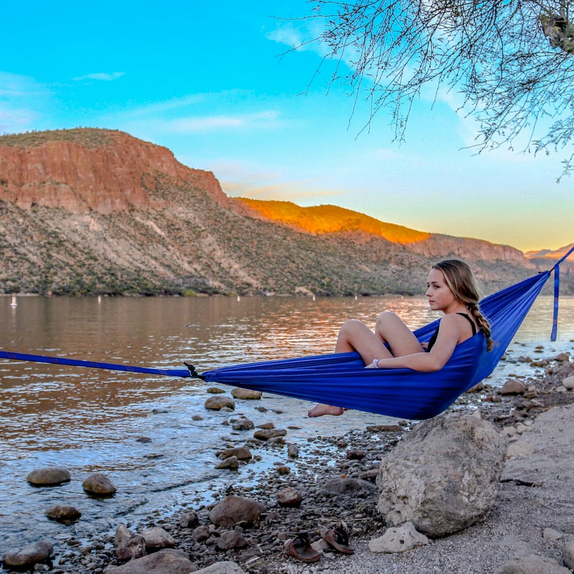 GrandTrunk ultralight starter hammock set up between two trees, showcasing its compact design and vibrant color.