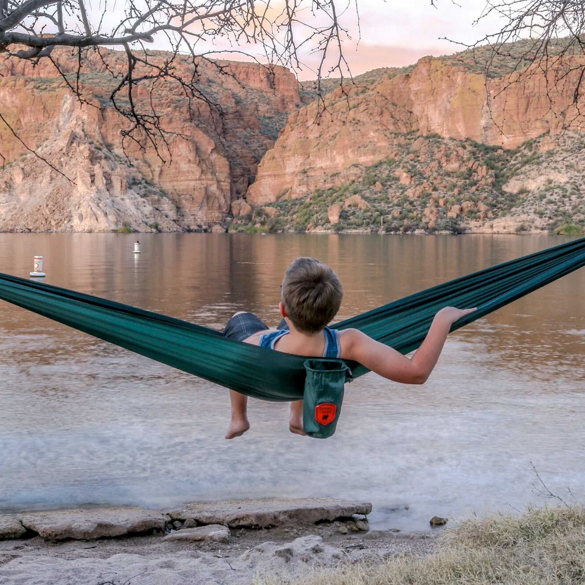 GrandTrunk ultralight starter hammock suspended between trees in a serene outdoor setting, showcasing its lightweight design.