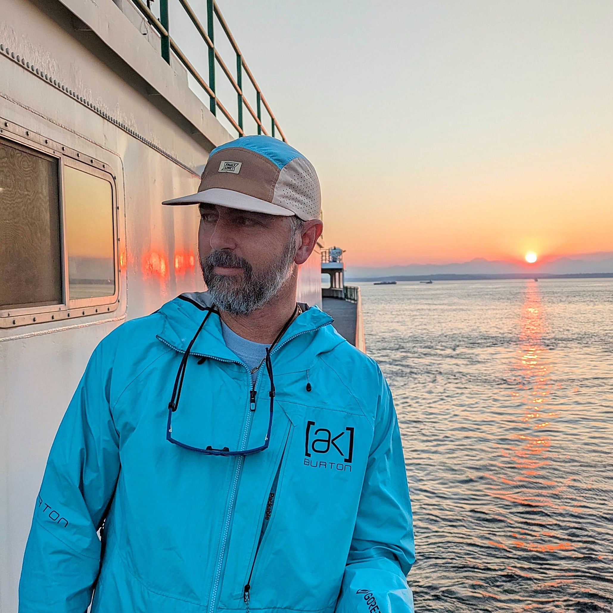 Faultline395 crushable 5-panel camper hat in tan and teal with a flexible brim and adjustable strap, designed for outdoor wear.