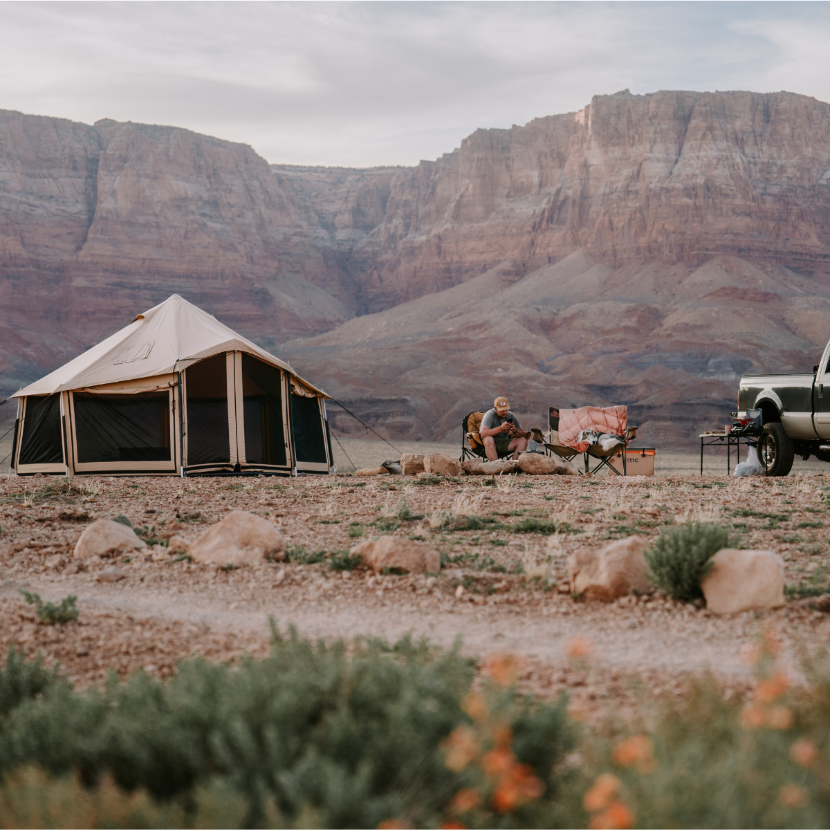 White Duck Outdoors Altimus Bell Tent set up outdoors with its spacious canvas design and sturdy wooden poles.