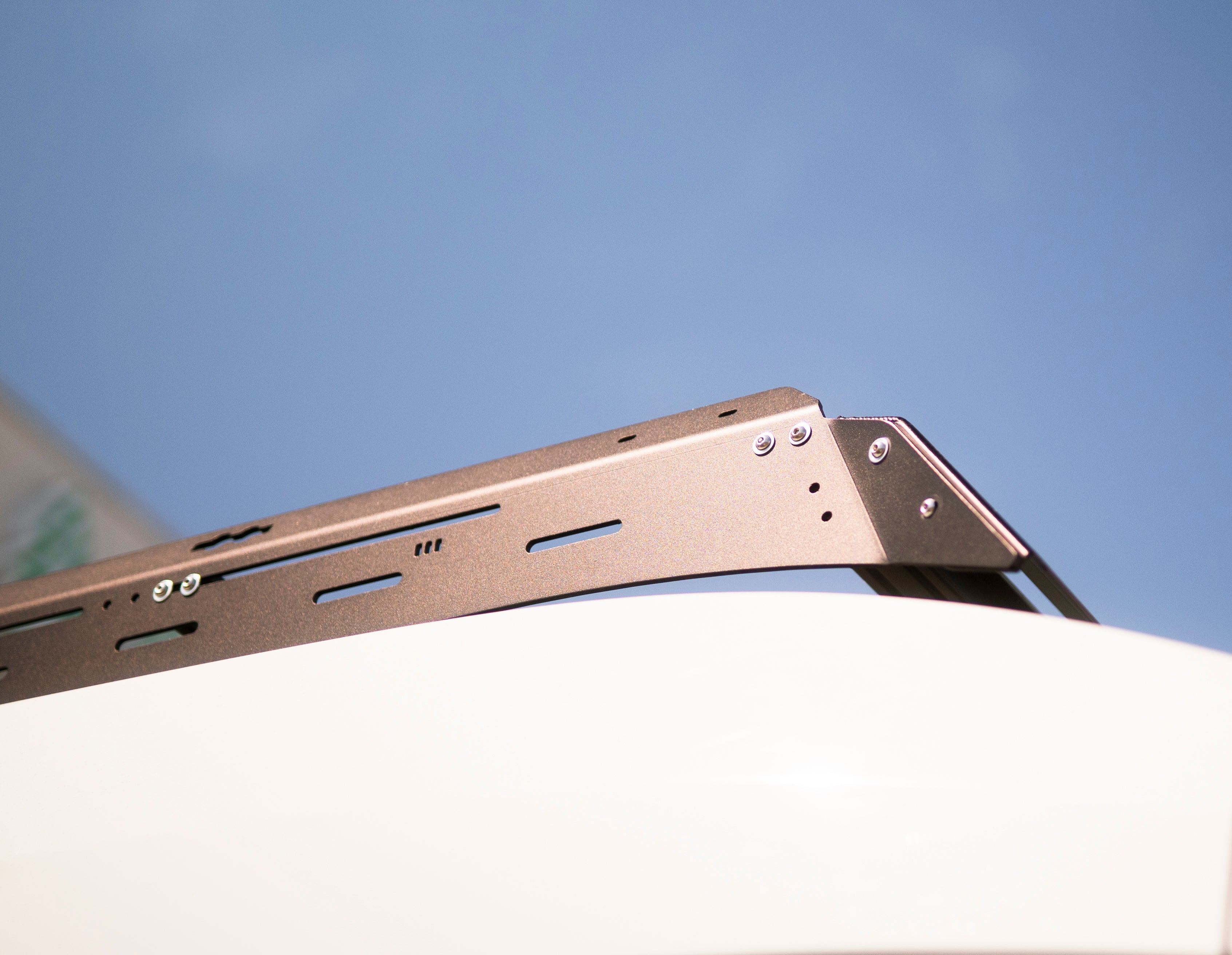The Van Mart Transit Scout Rack 148 mounted on a vehicle, showcasing its sturdy design and versatile attachment features.