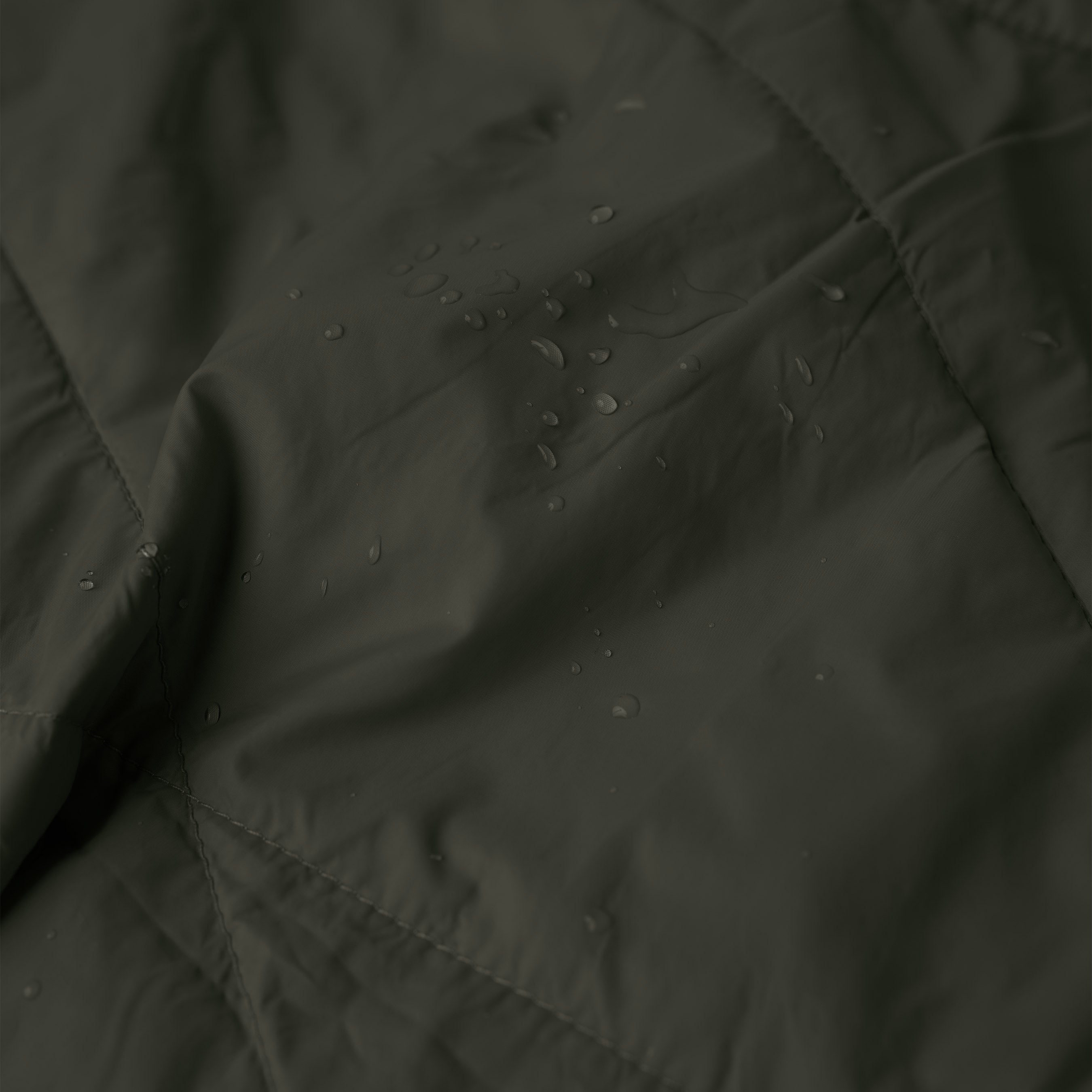 Gravel Layover™ Travel Blanket in Spruce color, soft and cozy fabric, shown spread out on a flat surface.