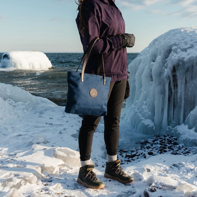 Backcountry Sportsman market tote with sturdy fabric and handles, shown on a lakewalk during winter adventure.