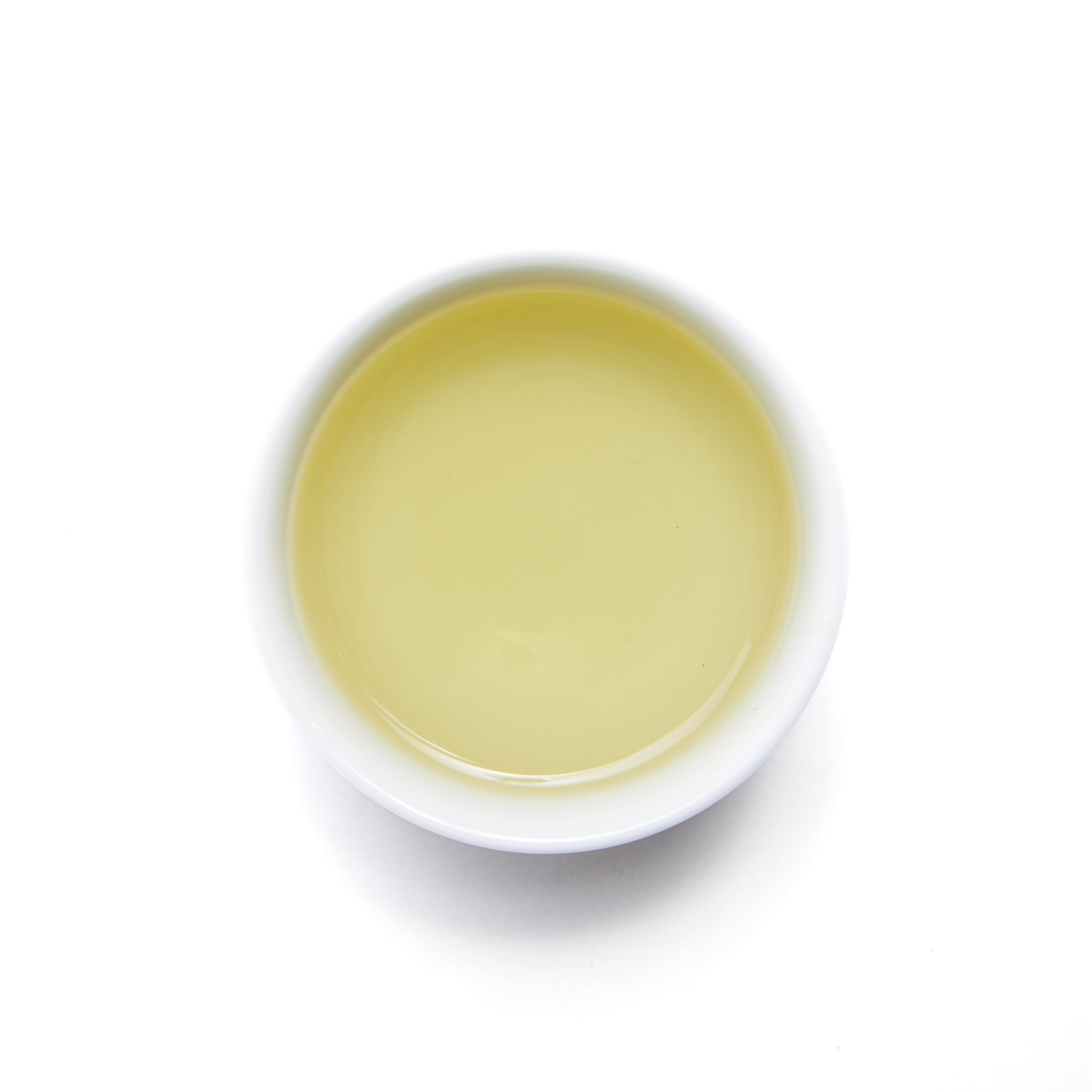 Brewed Wild Orchard Spring Green organic loose leaf green tea in a clear cup, showcasing vibrant green color.
