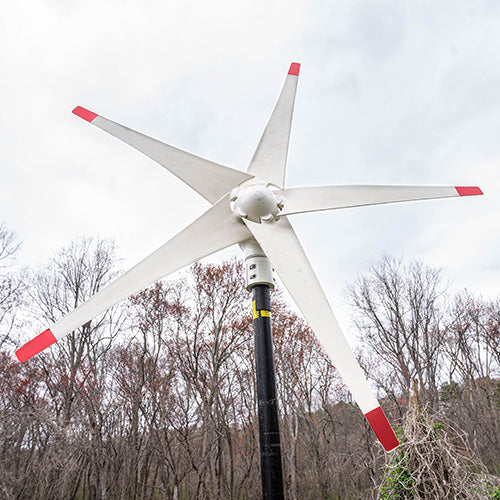 Nature's Generator 150W wind turbine for renewable energy, featuring blades and mounting stand in outdoor setting.