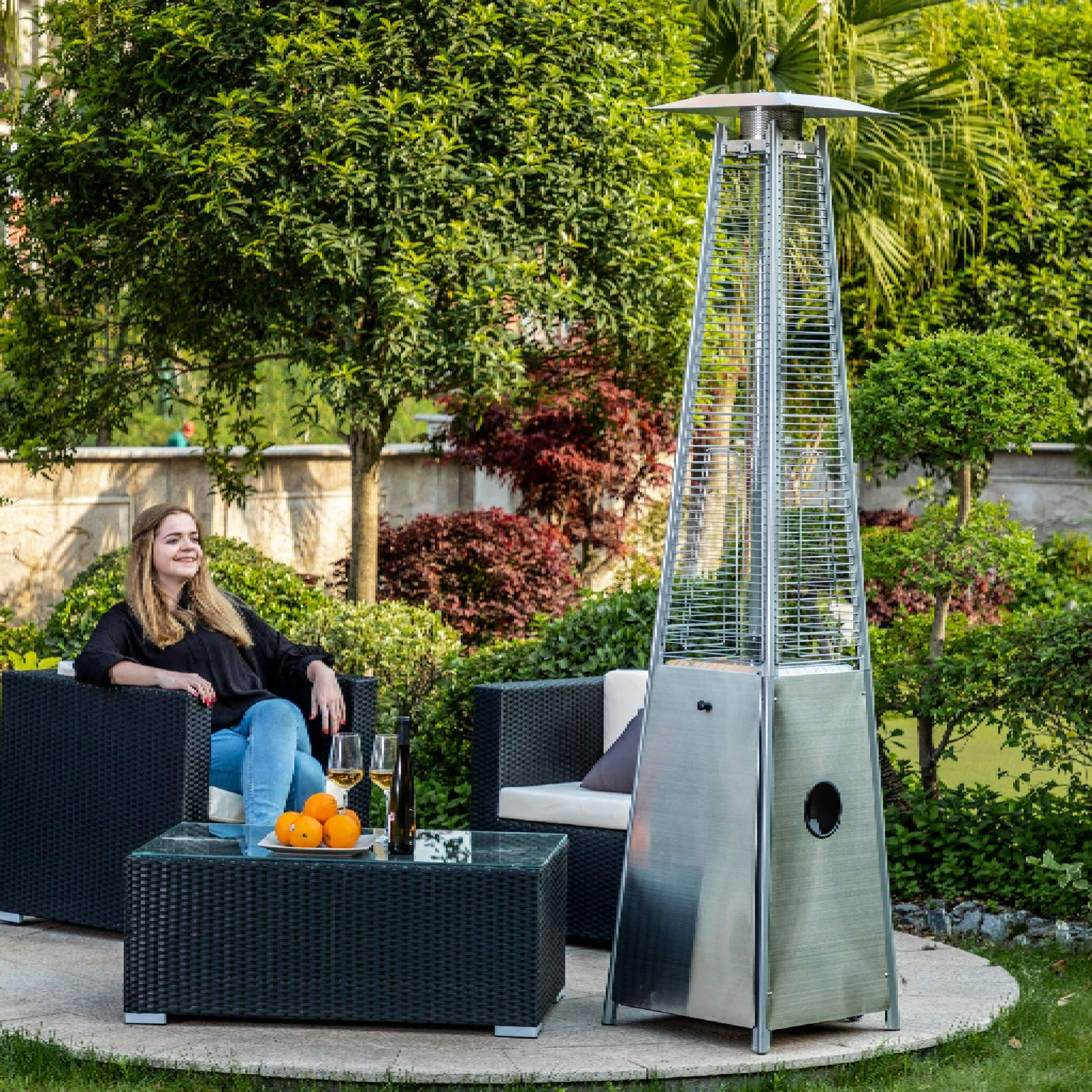 Alora Premium 40K BTU stainless steel patio heater with quartz glass tube, shown outdoors with a woman for scale.