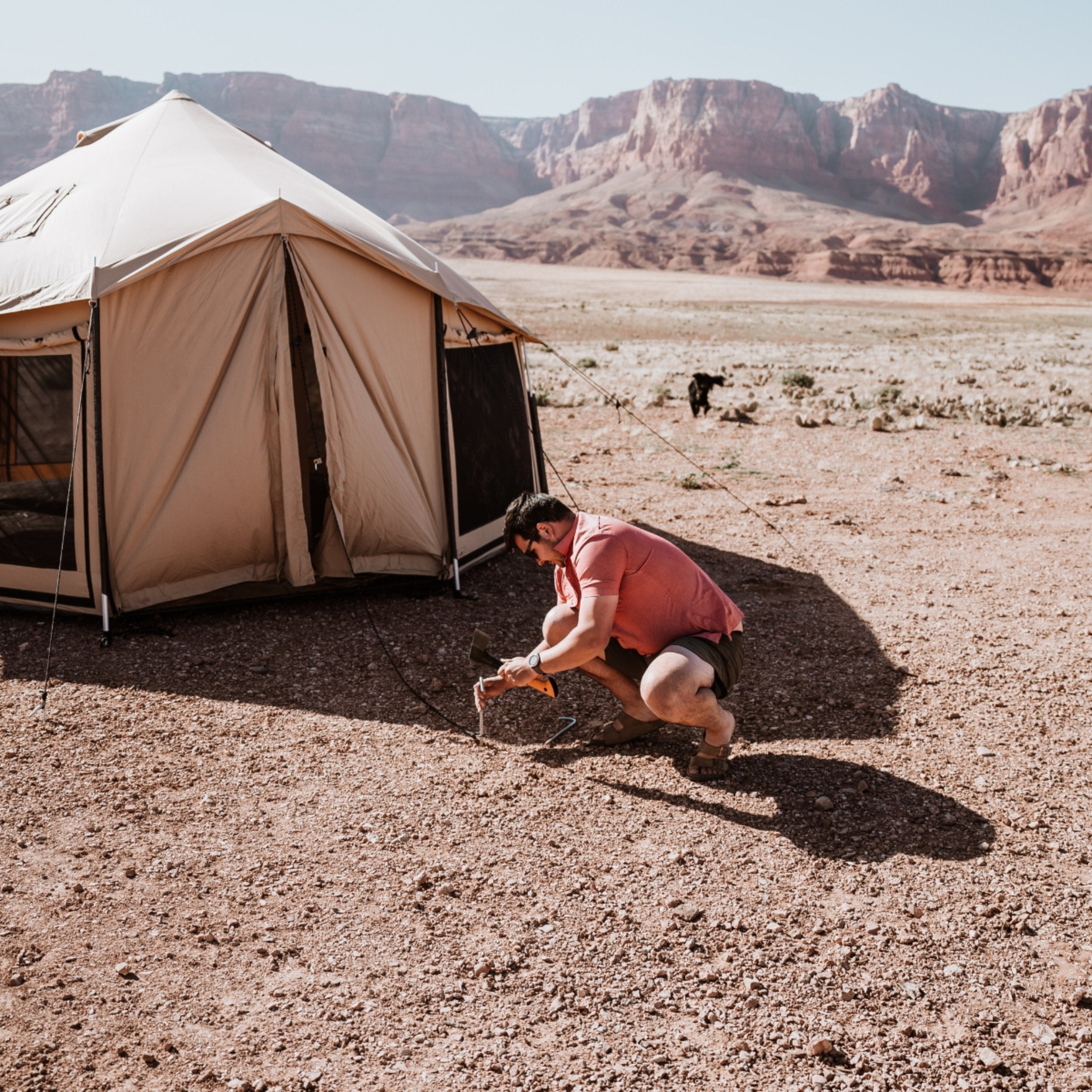 Altimus Bell Tent by White Duck Outdoors being secured to the ground with stakes on a grassy surface.