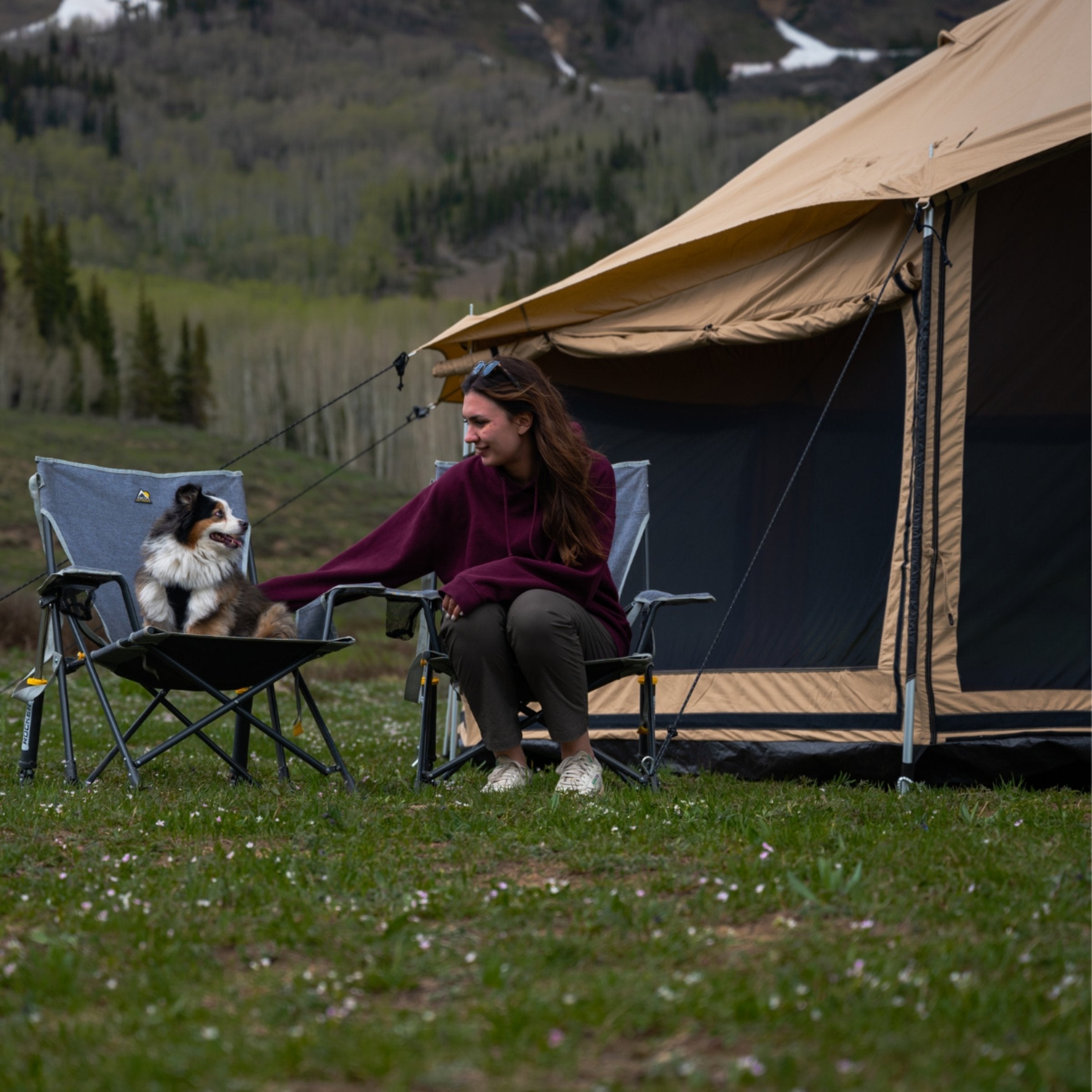 White Duck Outdoors Altimus Bell Tent set up outdoors with a woman and her dog in front of the tent. Durable, spacious camping shelter.