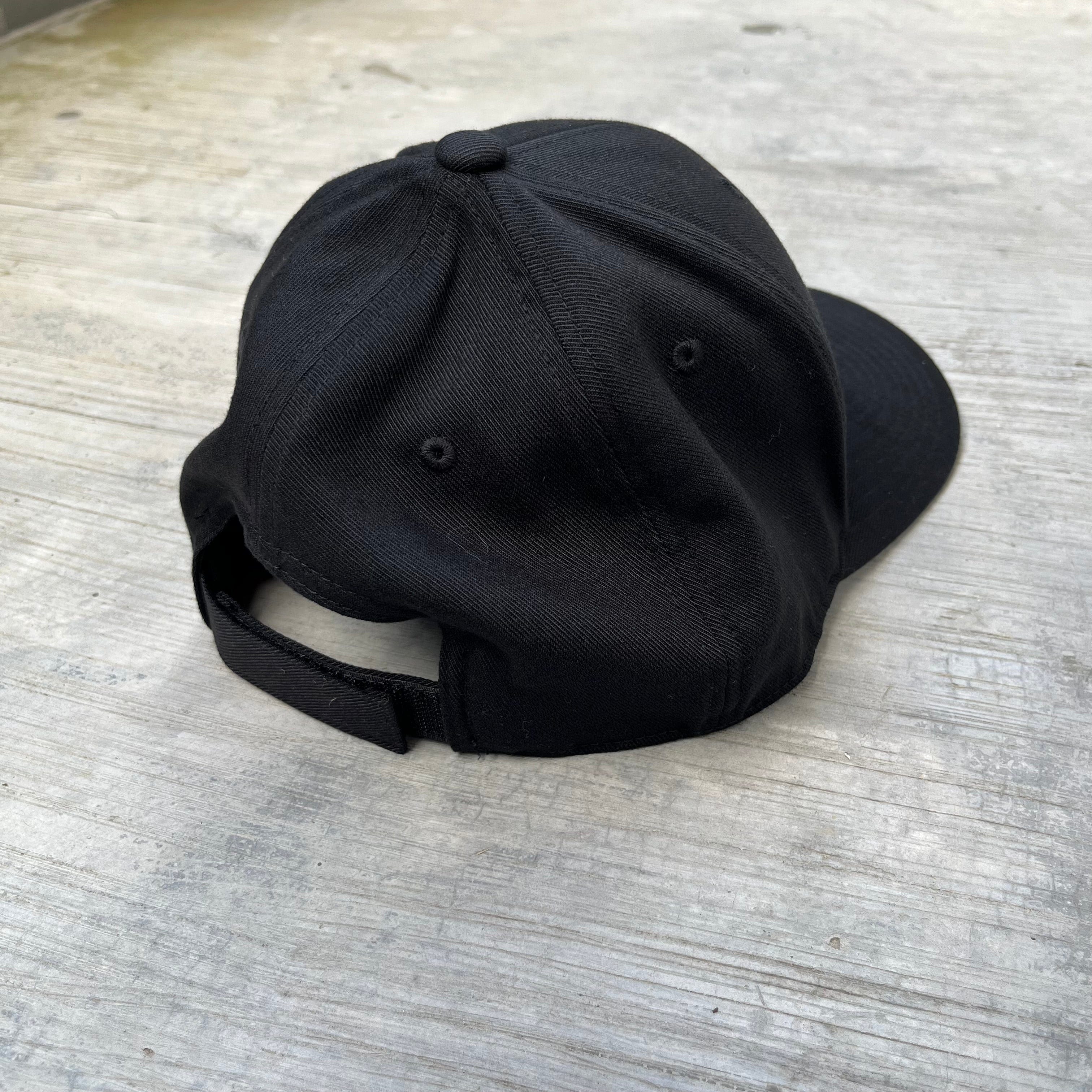 Black minimalist cap from SFT2 Tactical with a curved brim and adjustable strap, designed for a sleek, modern look.