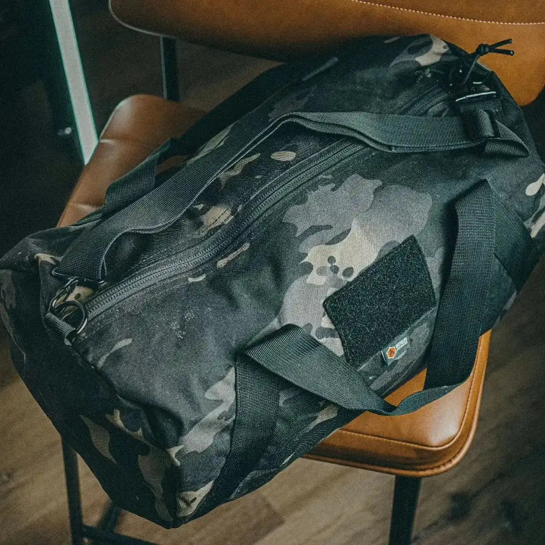 Recycled Firefighter Barrel Duffle Bag 1000D made of durable material, versatile backpack with black camouflage design and sturdy handles.