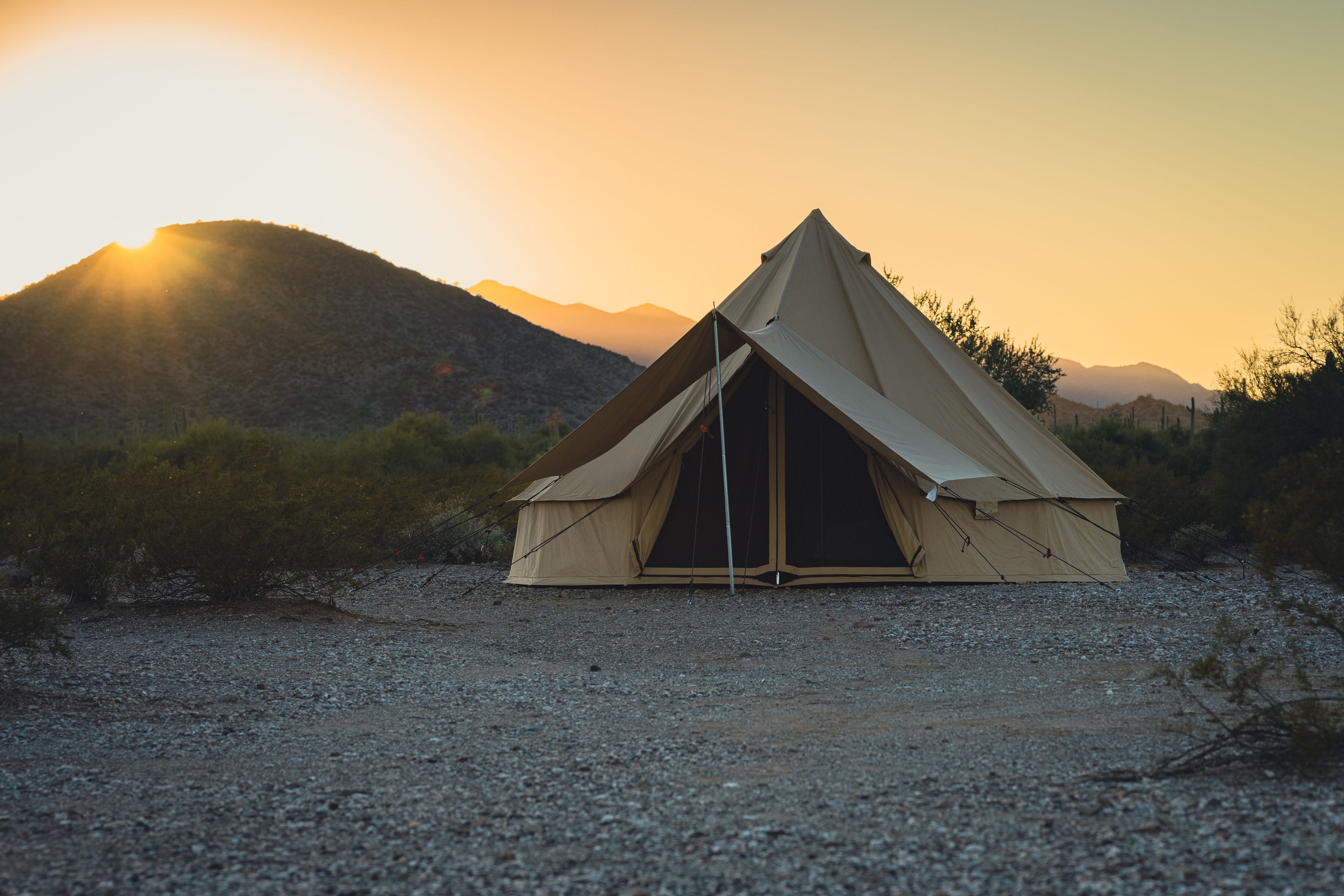 Open Regatta Bell Tent awning by White Duck Outdoors set up outdoors, showing its spacious design and durable fabric for camping.