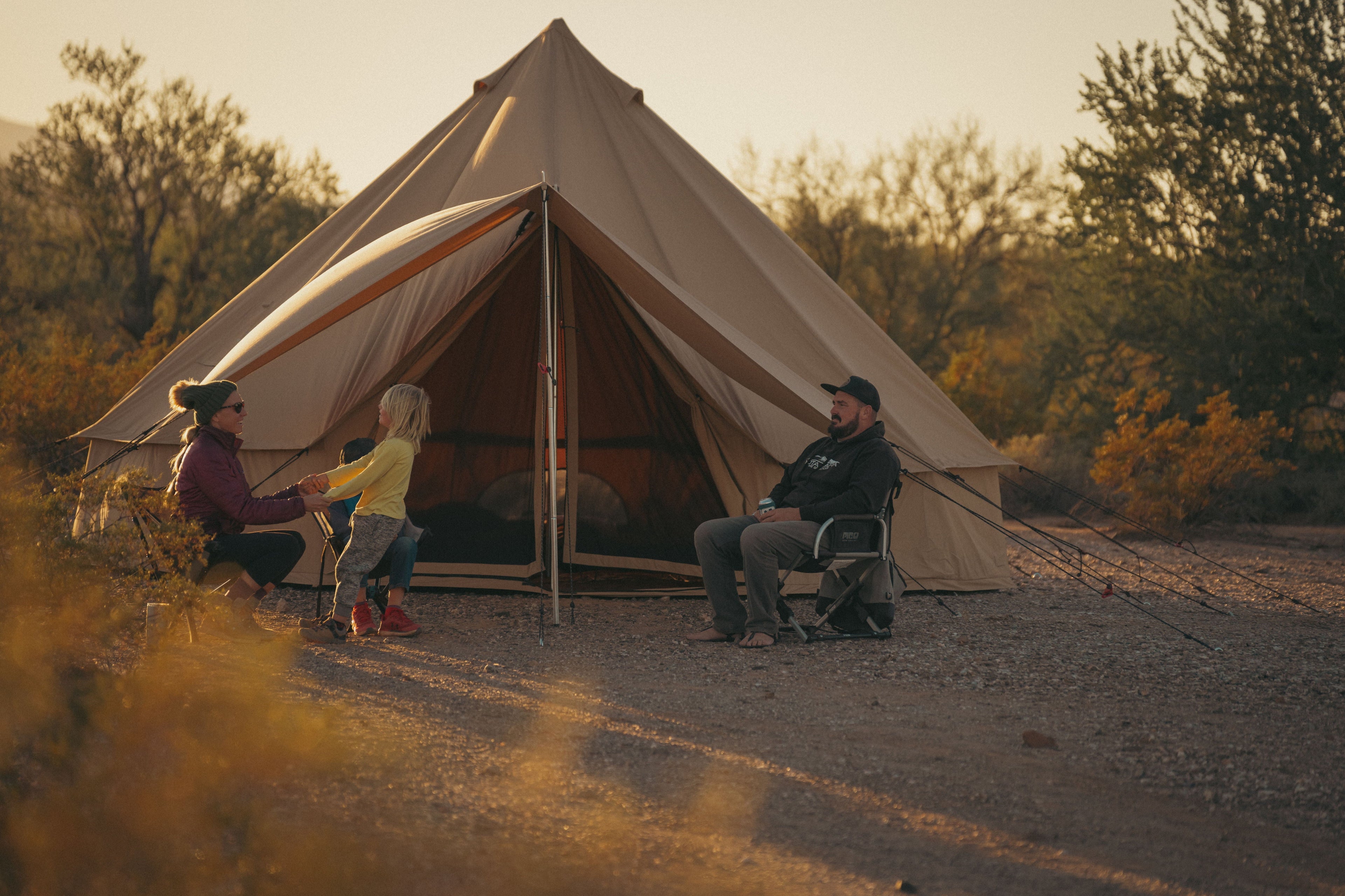 White Duck Outdoors Regatta awning attached to a bell tent, with a family enjoying outdoor shade and shelter.