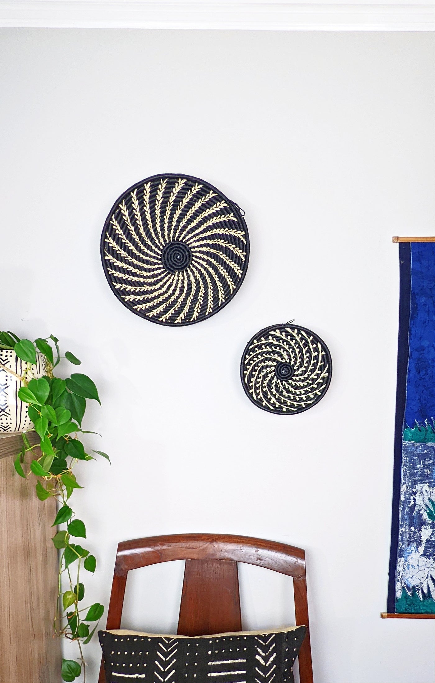 Small woven Raffia African baskets in multiple colors displayed on a wall, showcasing artisanal craftsmanship and vibrant design.