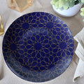 Set of four blue mosaic appetizer plates by Tea + Linen, featuring vibrant geometric patterns for serving small dishes.