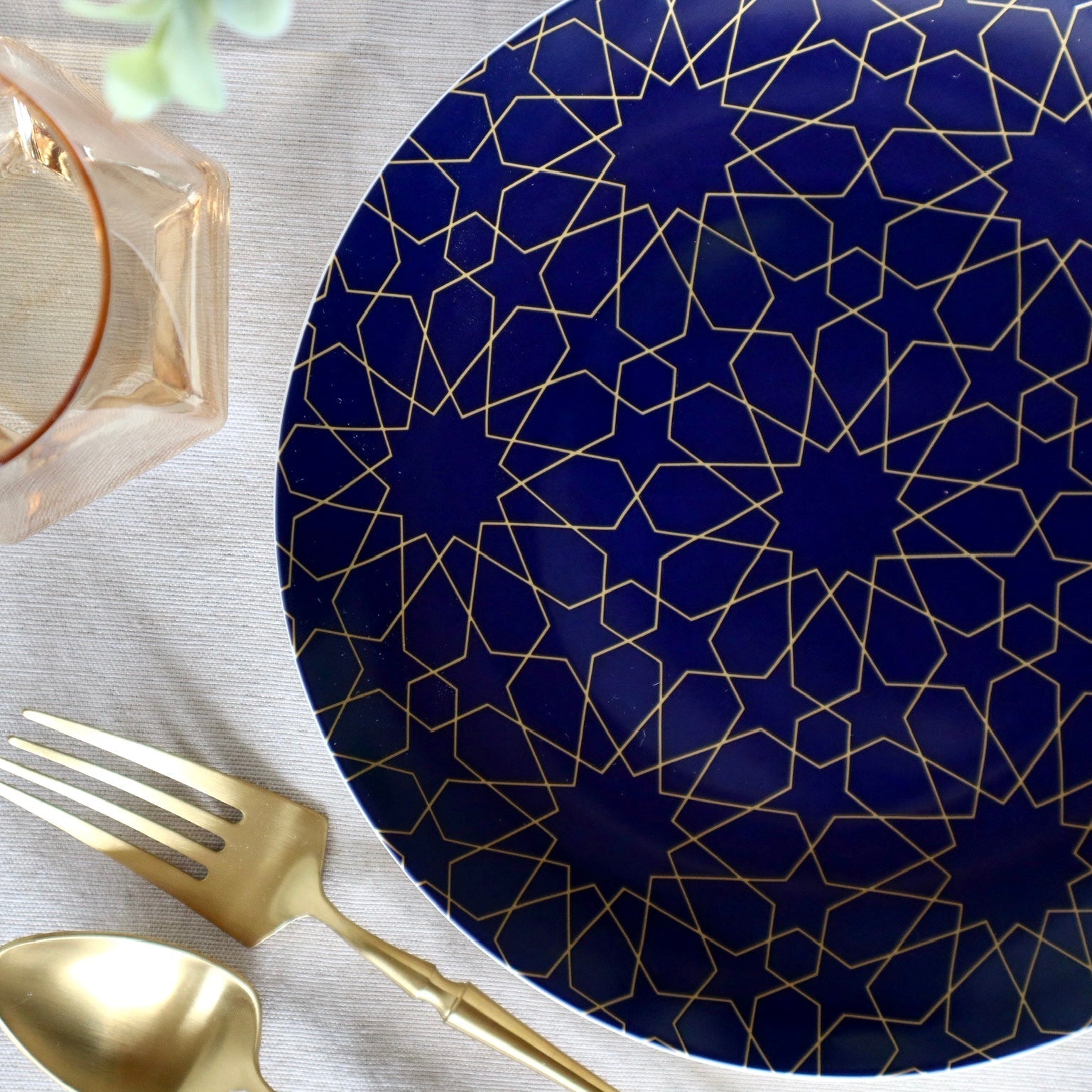 Set of four blue mosaic appetizer plates by Tea + Linen, featuring vibrant geometric patterns for serving small bites.