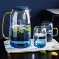 Blue ombre glass pitcher and cups set by Tea + Linen, showcasing a gradient design in a vibrant blue color.