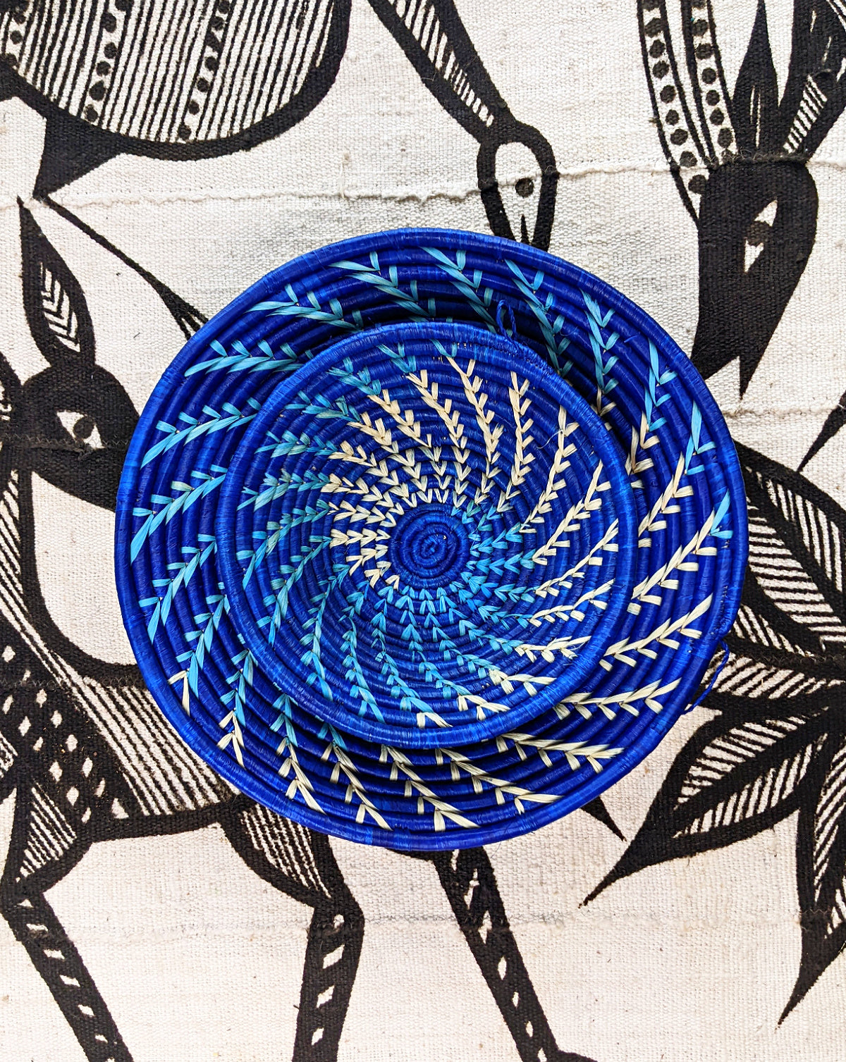 Large blue and white woven African basket by Reflektion Design, featuring intricate craftsmanship and vibrant colors.