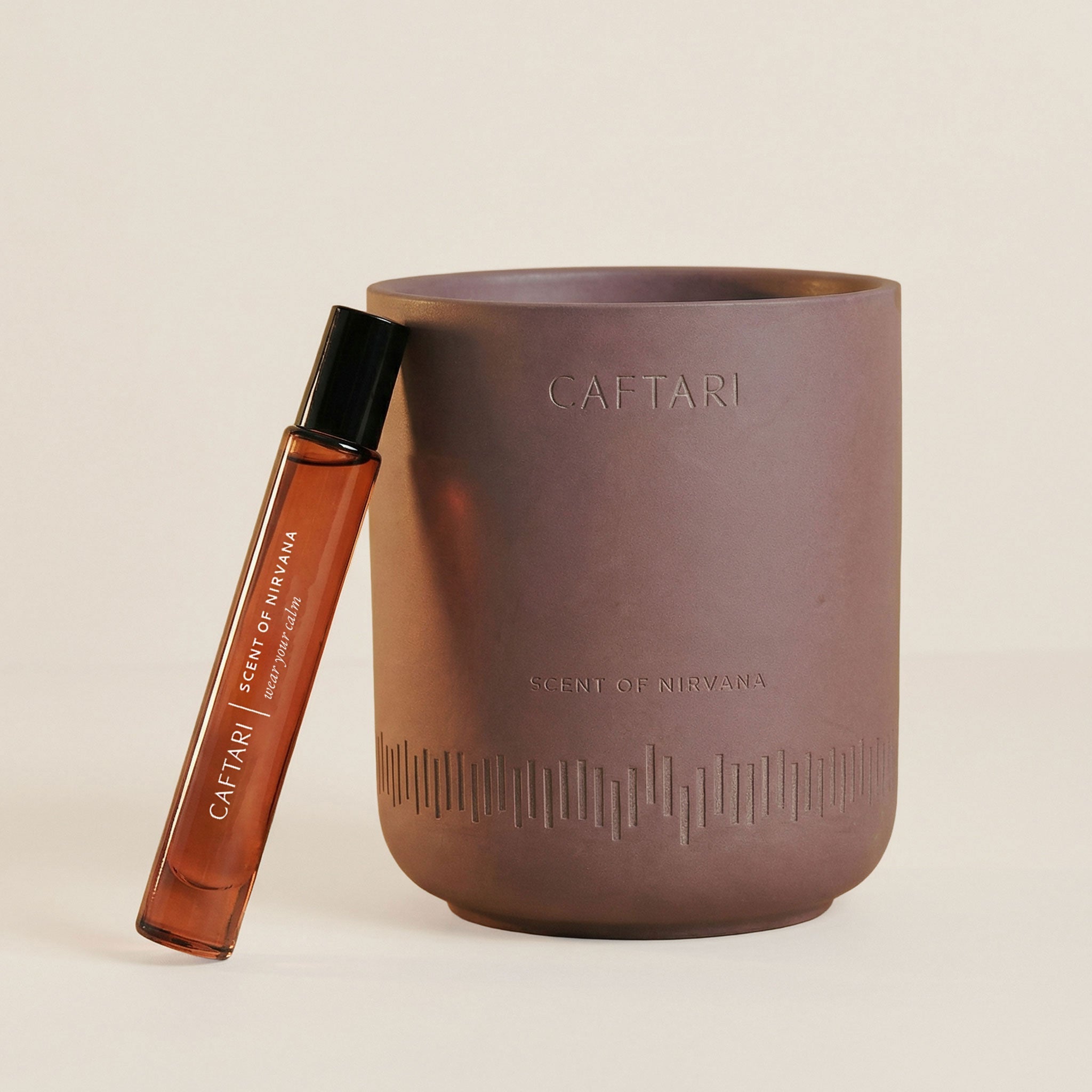 Caftari Scent of Nirvana candle and rollerball perfume set featuring oud, praline, and agarwood notes in elegant packaging