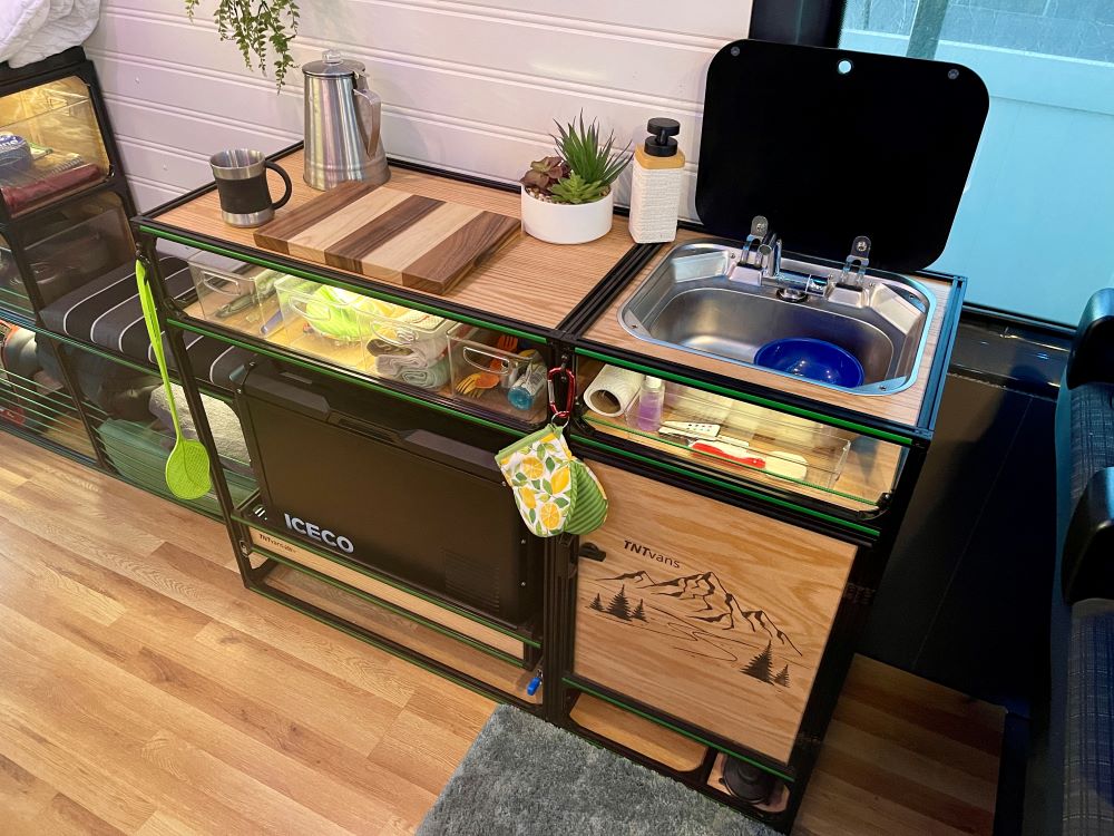 Mercedes Sprinter 170 campervan conversion DIY kit by TNTvans featuring a kitchen sink with tanks inside a camper van.