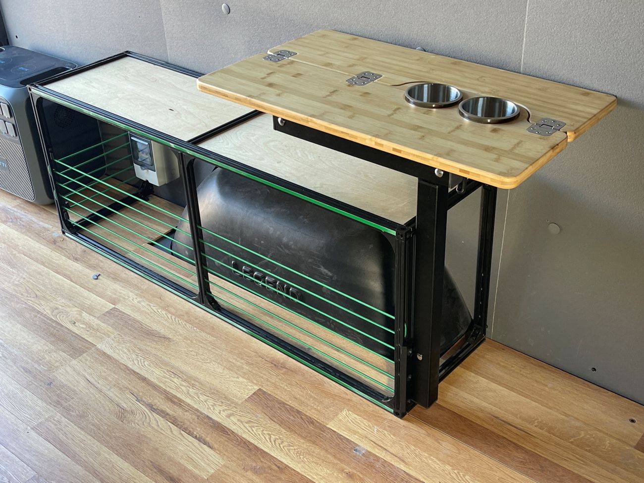 Foldable camper van wheel well bench storage from TNTvans, designed for DIY van conversions with a sturdy wooden surface