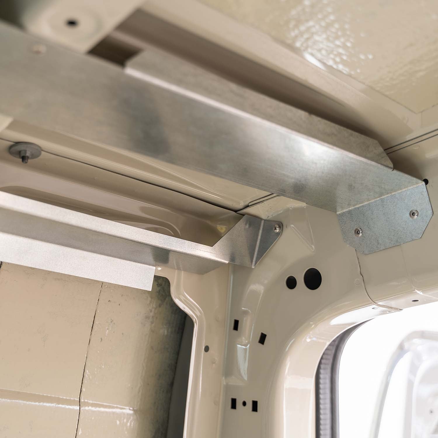 Timber Van Kits overhead cabinet panels for transit vans, showing structural assembly with wood panels and mounting hardware.