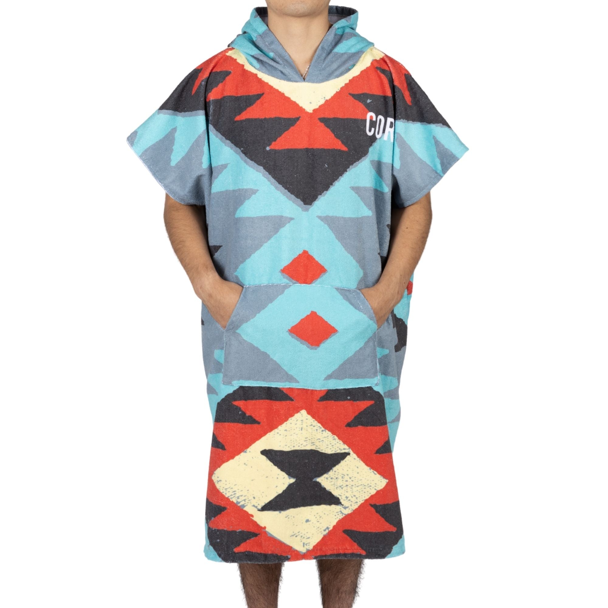 Close-up of COR Surf Surfer Bundle gift pack with tribal-style changing towel poncho, surf rack, change mat, and wax accessories.