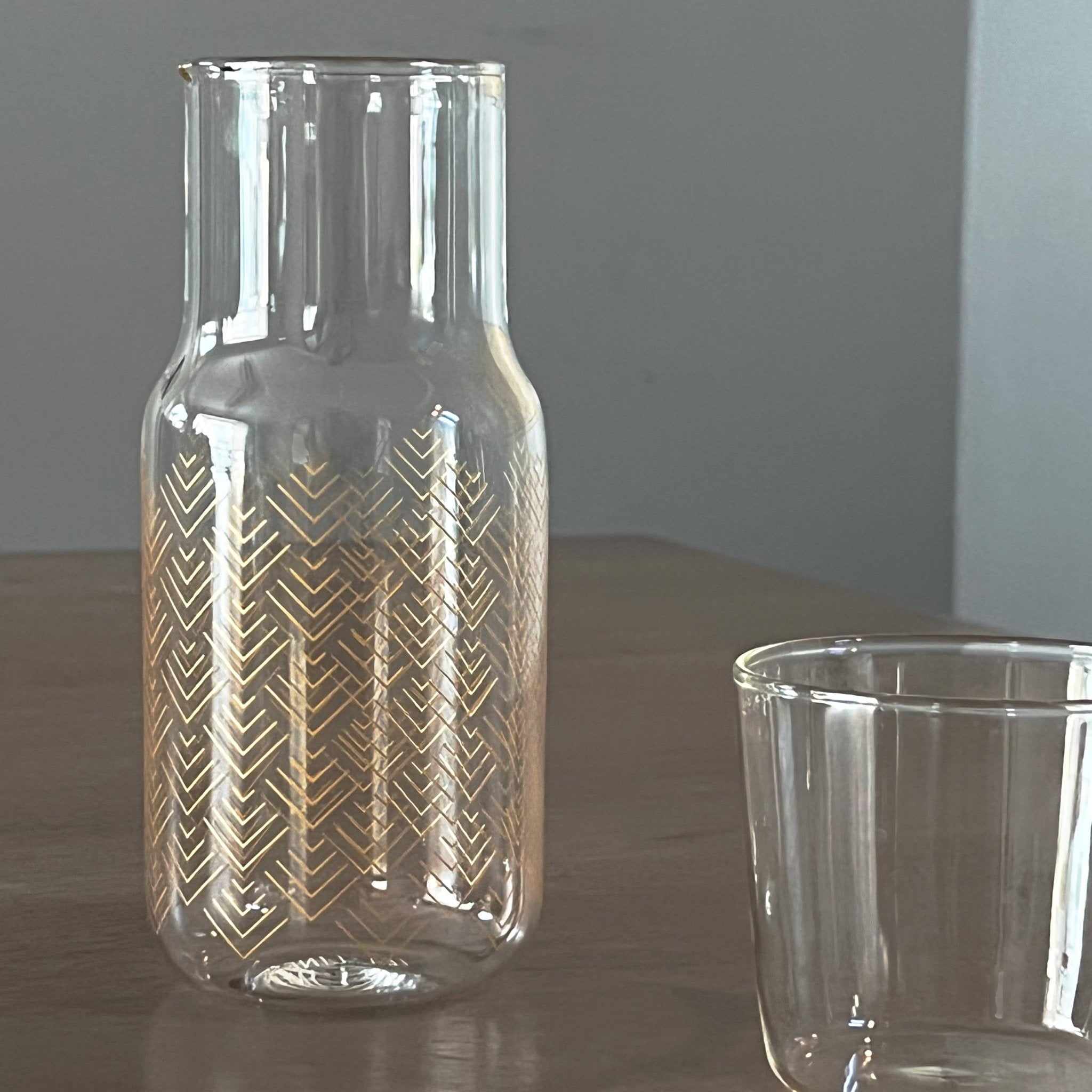 Tea + Linen Chevron Bedside Carafe with a geometric chevron pattern, made of clear glass perfect for bedside or table display.