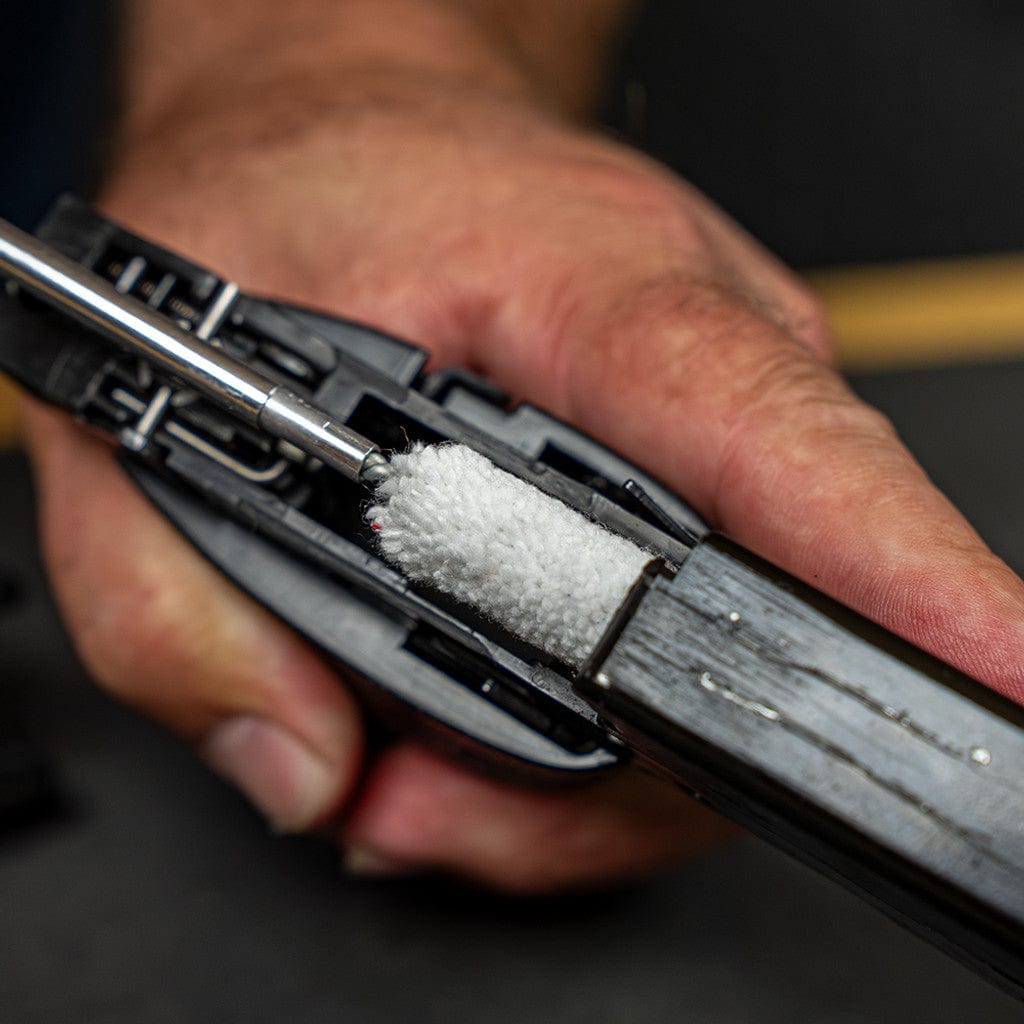 SFT2 Tactical rifle caliber cleaning kit with brushes and tools displayed on a wooden surface.