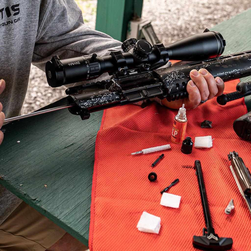 SFT2 Tactical rifle caliber cleaning kit with brushes, rods, and patches arranged on a workbench.