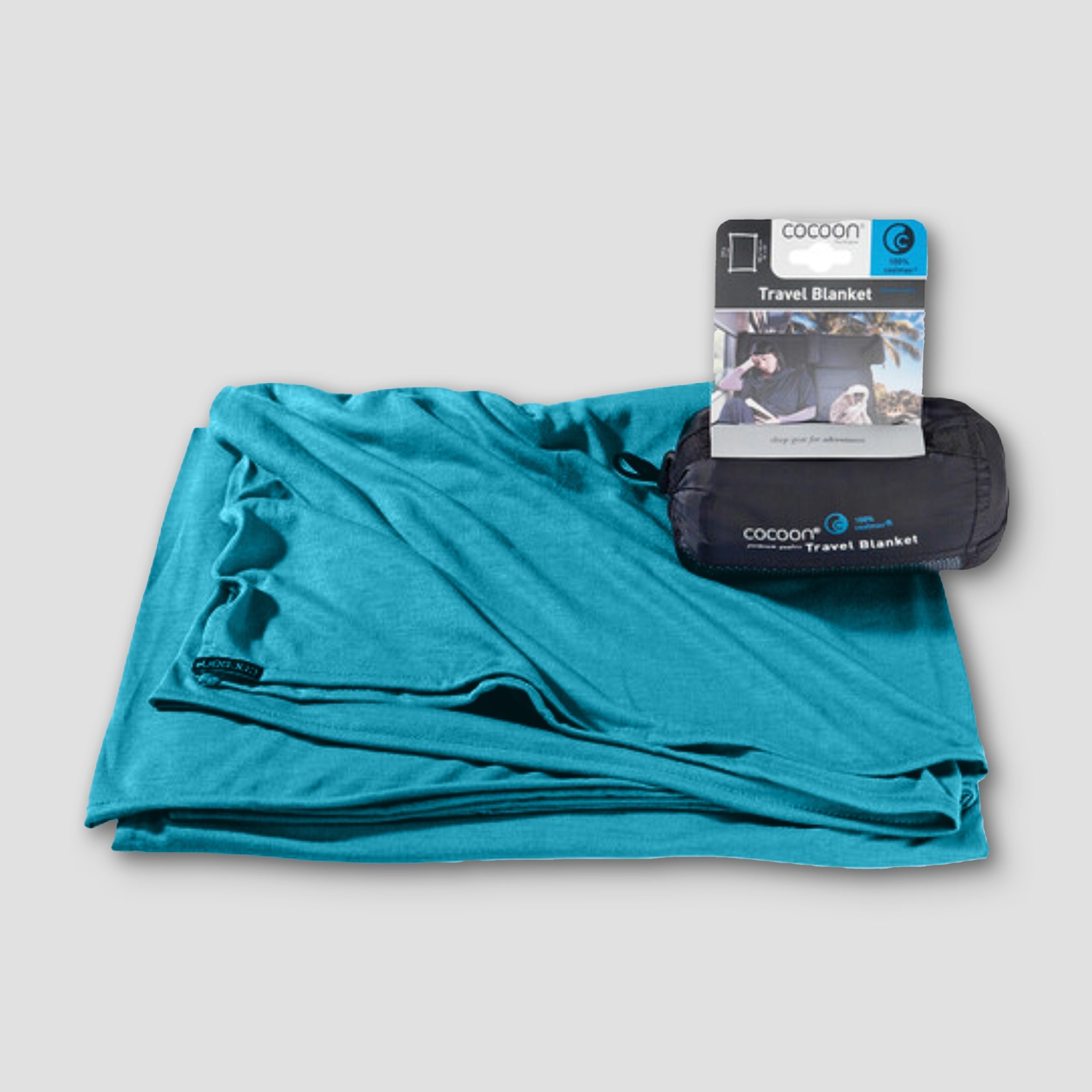 COCOON COOLMAX® travel blanket folded on a surface, showcasing its lightweight, breathable fabric and compact design.