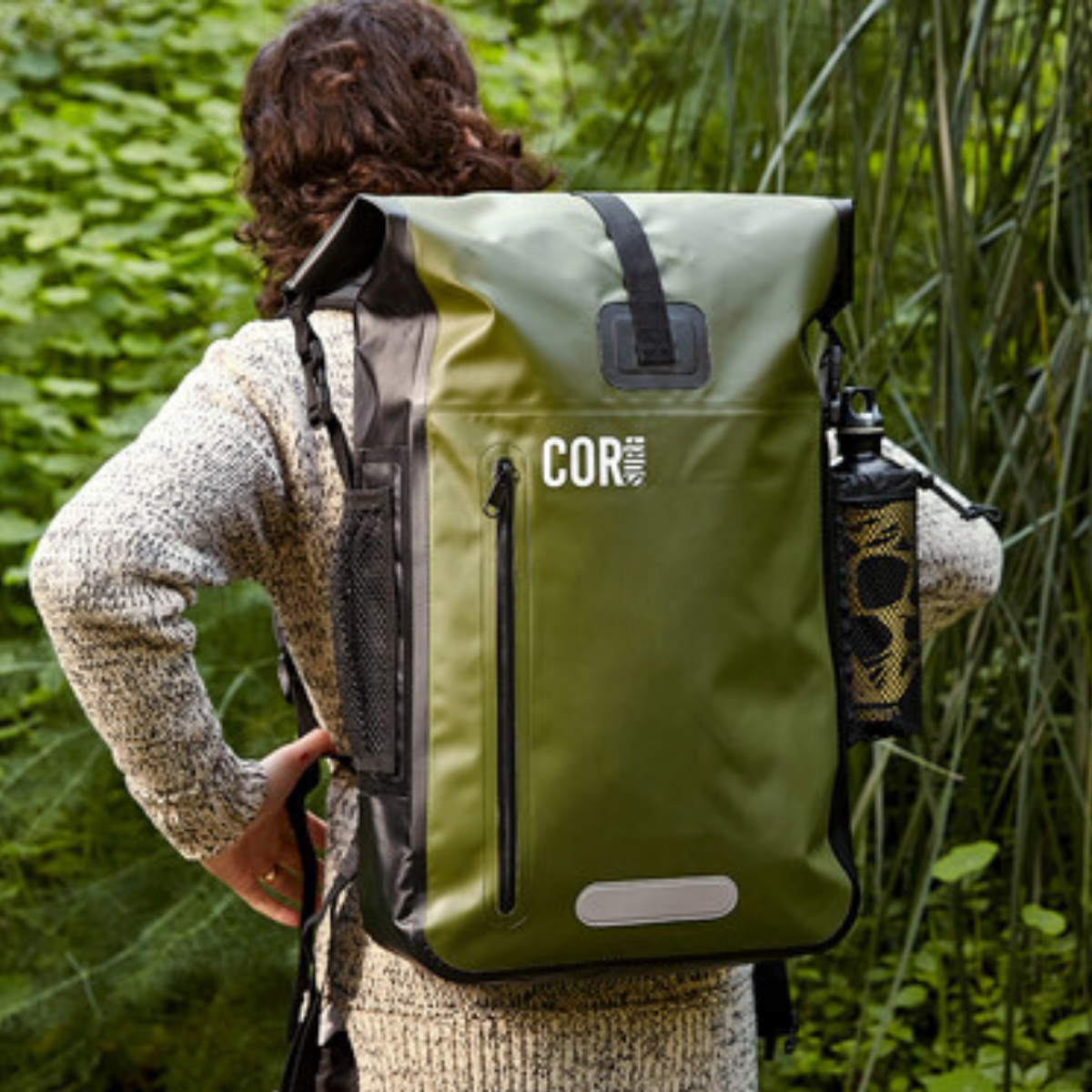 Green COR Surf 40L waterproof dry bag backpack with adjustable straps and roll-top closure for outdoor water activities.