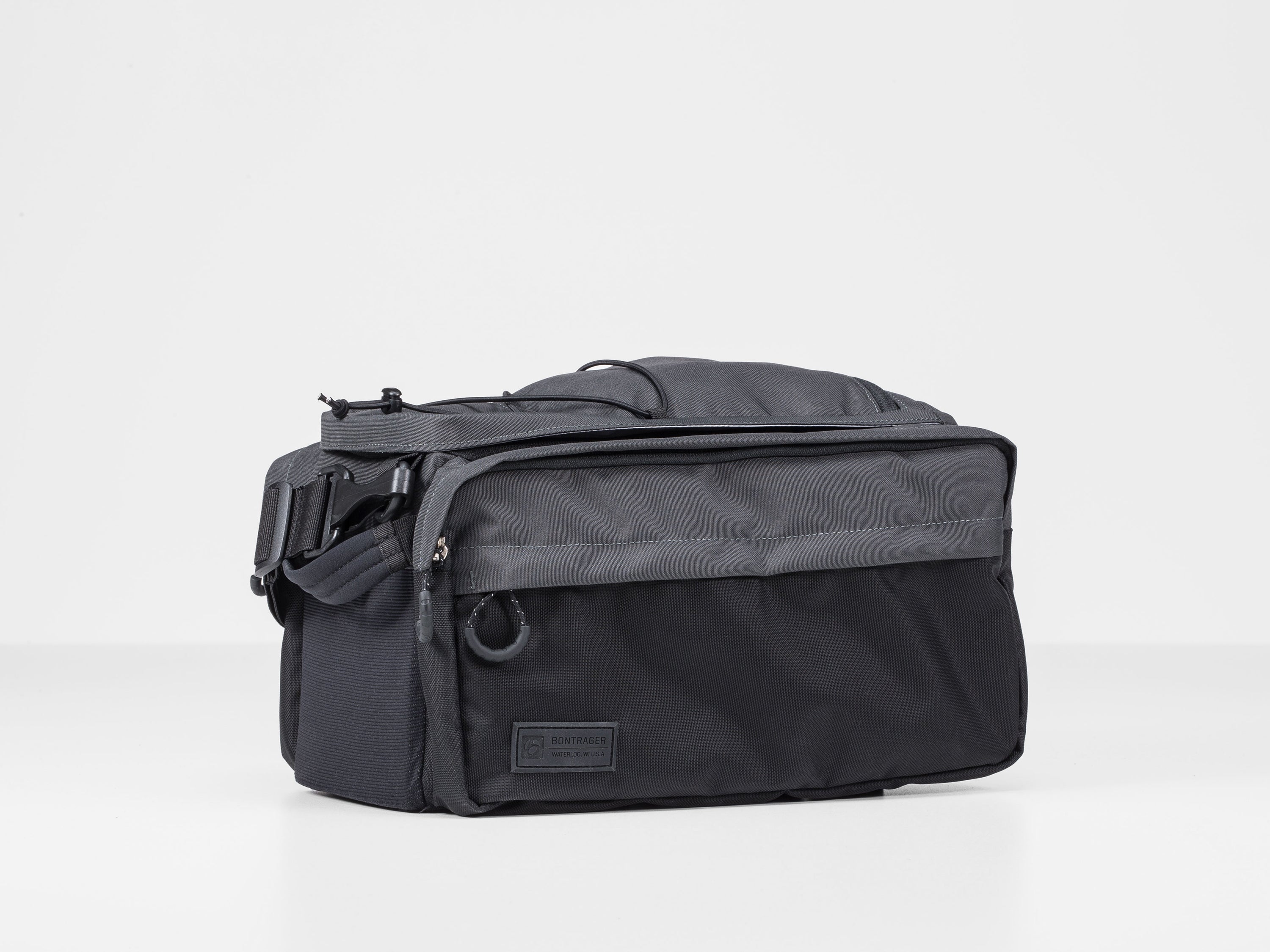 Black Bontrager MIK Utility Trunk Bag attached to a bike rack, showcasing durable storage for cycling gear by Gio's Outdoors.
