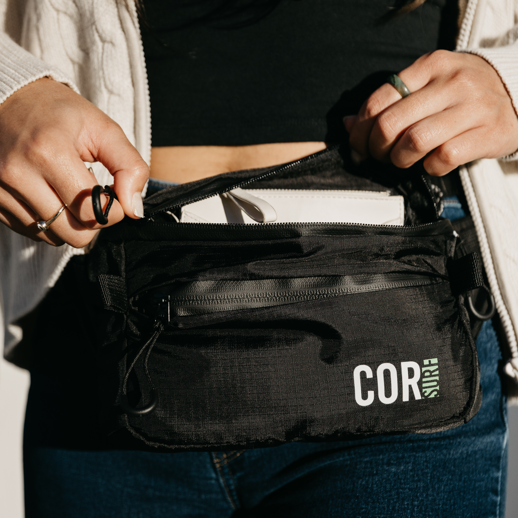 Black COR Surf Daily Cross-Body hip pack with 1L capacity, featuring adjustable strap and compact design for convenient everyday use.