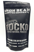 Ethiopian natural process coffee beans in a darker roast from Iron Bean Coffee Company, showcasing rich color and texture.