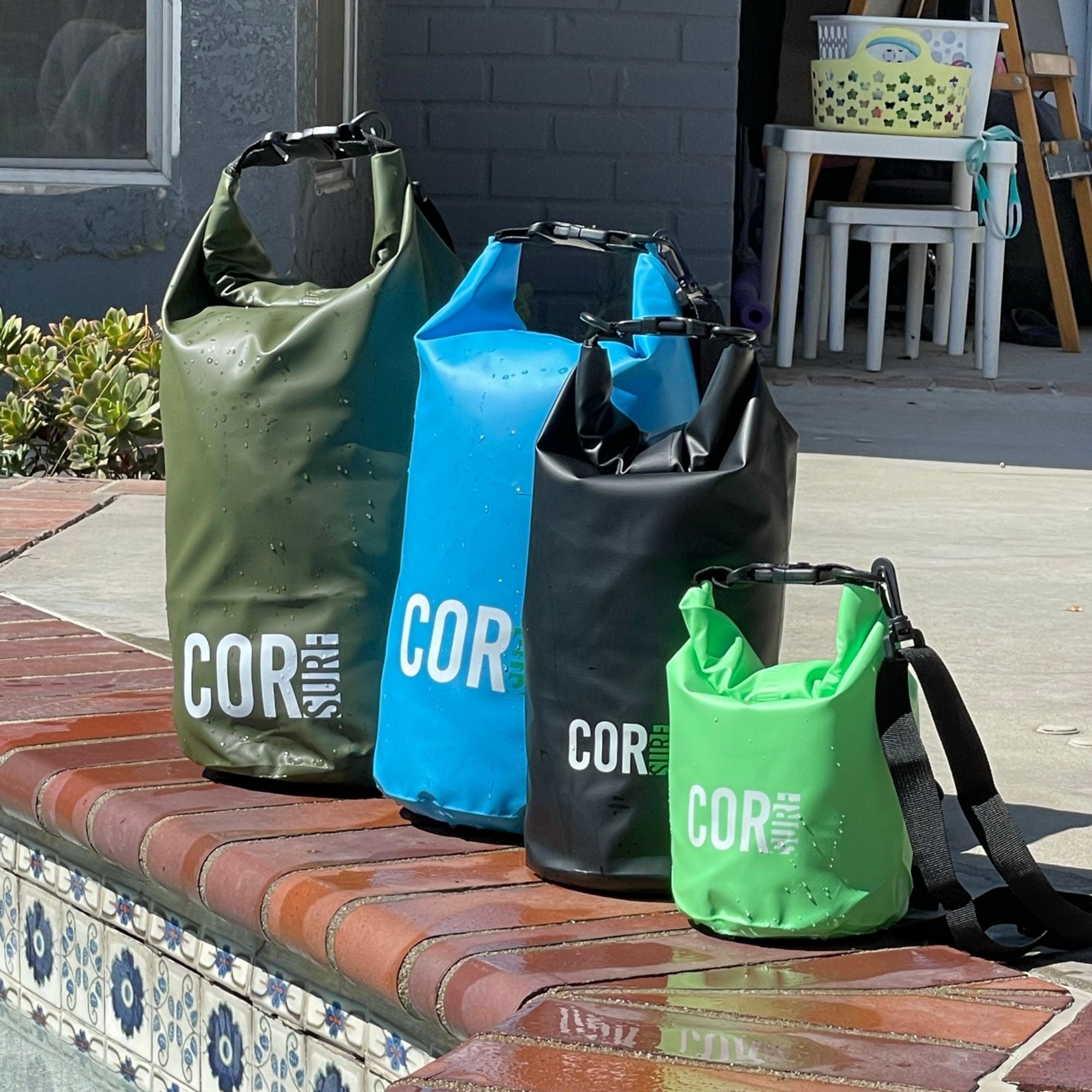 Set of four COR Surf dry bags in 3L, 5L, 10L, and 15L sizes with waterproof material and adjustable straps.