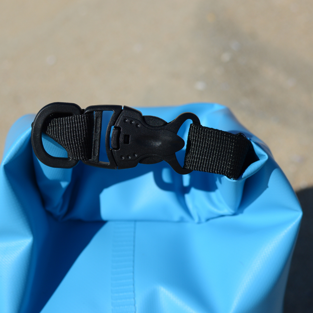 Close-up of a COR Surf dry bag clip showing secure closure, available in 3L, 5L, 10L, and 15L sizes for waterproof storage.