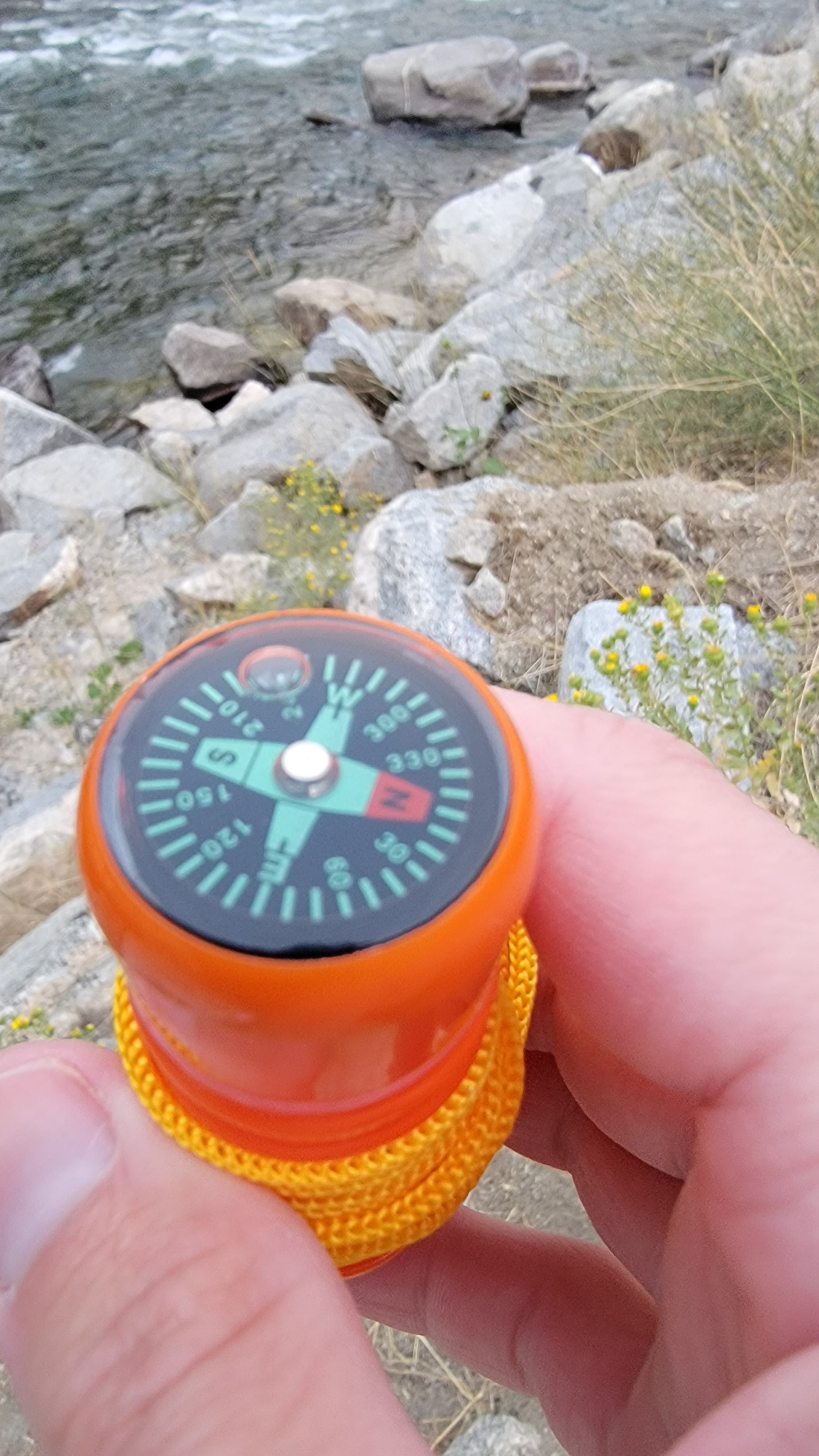 Five-in-one survival whistle with built-in compass and lanyard, essential outdoor emergency tool for camping and hiking.