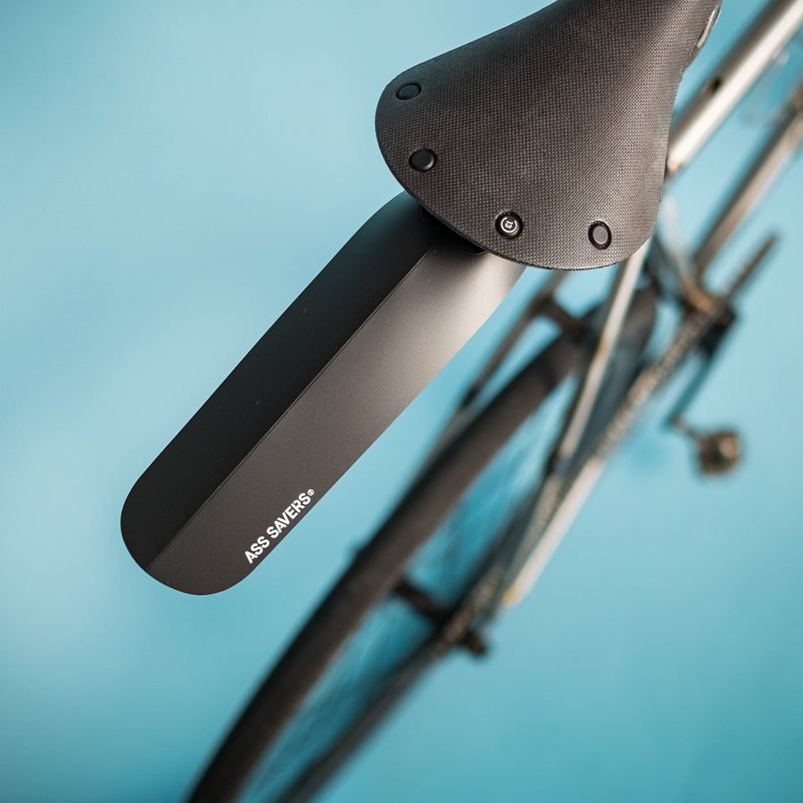 Black ZEITBIKE ASS SAVERS Regular Size rain fenders attached to bicycle wheels in a natural outdoor setting.