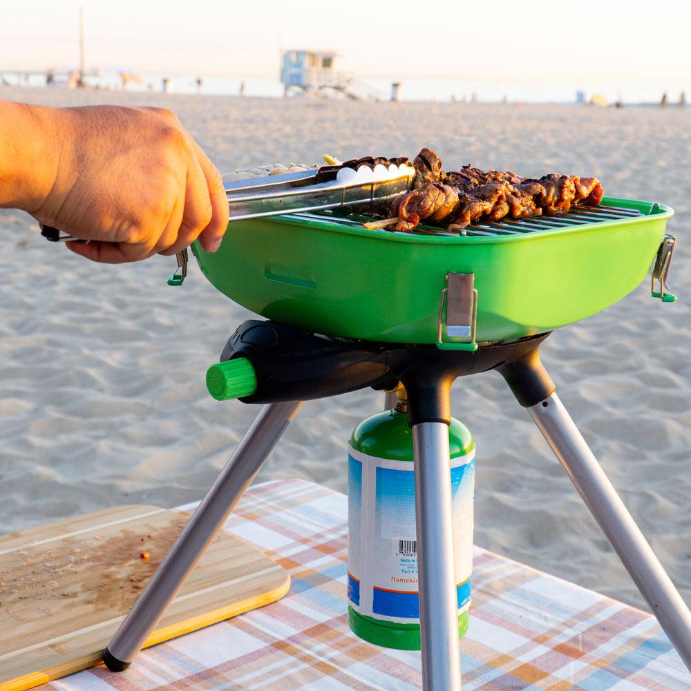 Portable Flame King camping BBQ grill and camp stove with multiple cooking functions, ideal for outdoor camping and grilling.