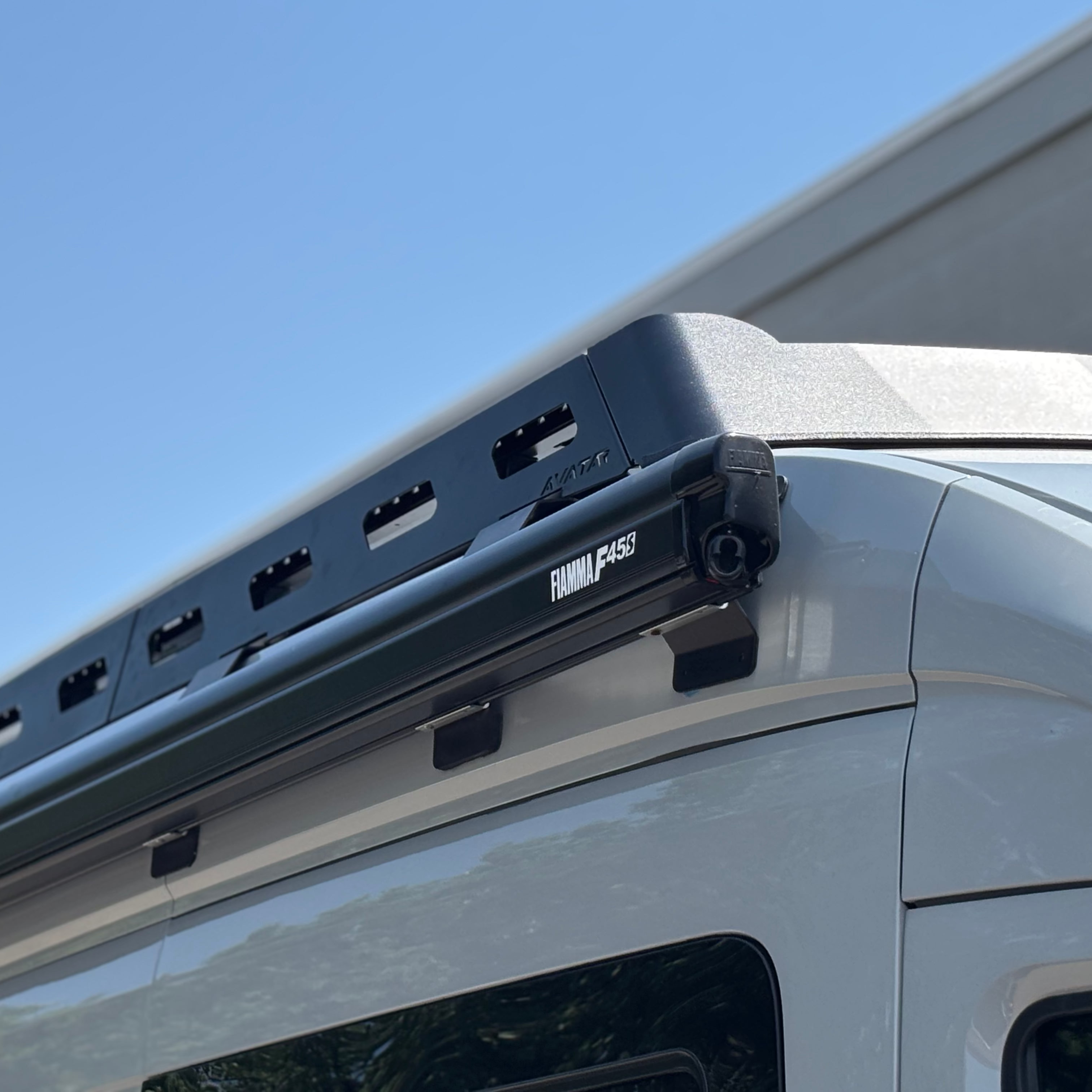 Ford Transit van with Avatar Offroad Pioneer Transit Roof Rack installed on the roof for extra cargo space.