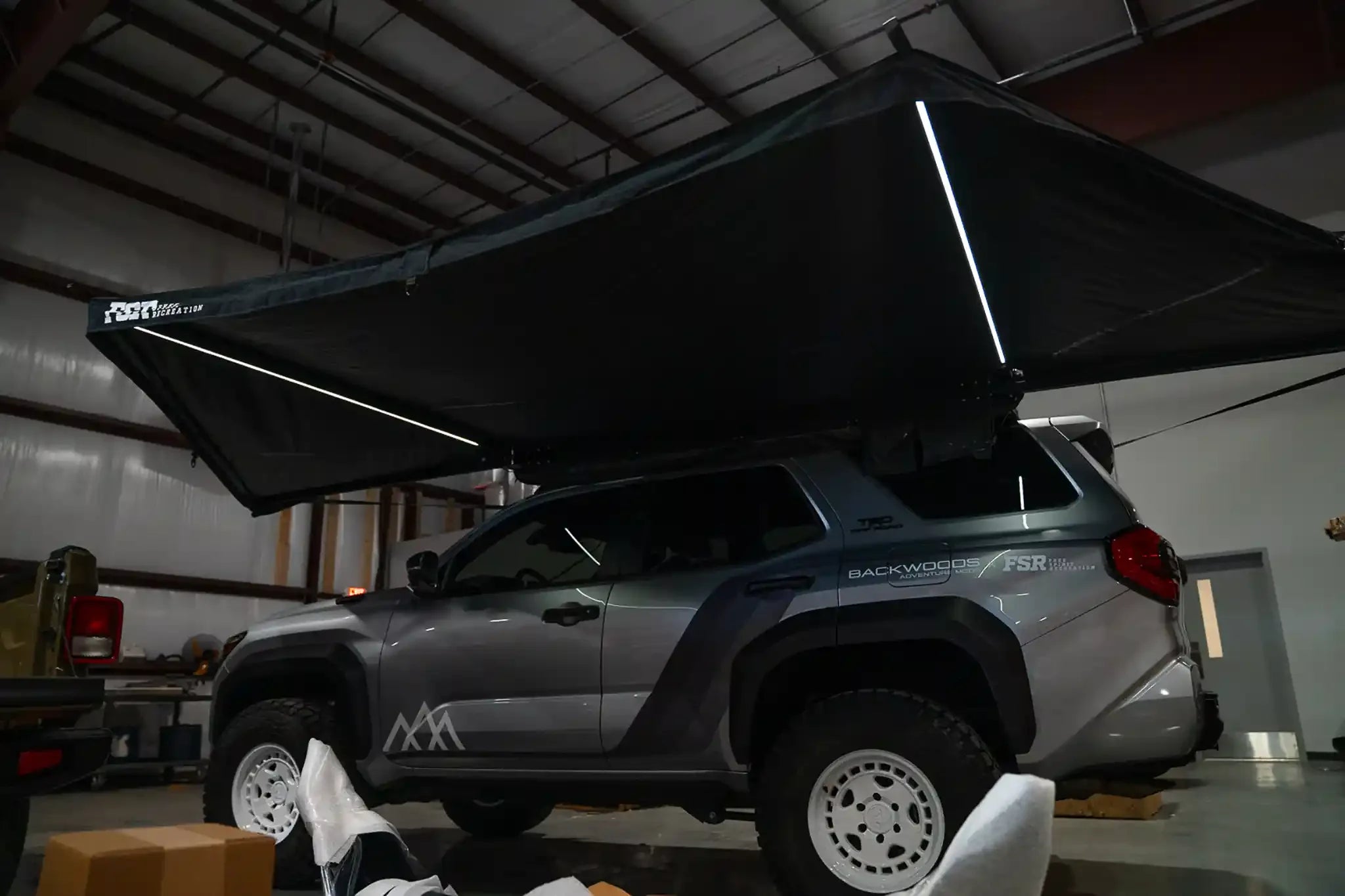 White Freespirit Recreation 180 Awning V2 with integrated LED lights, showcasing its durable fabric and spacious design.