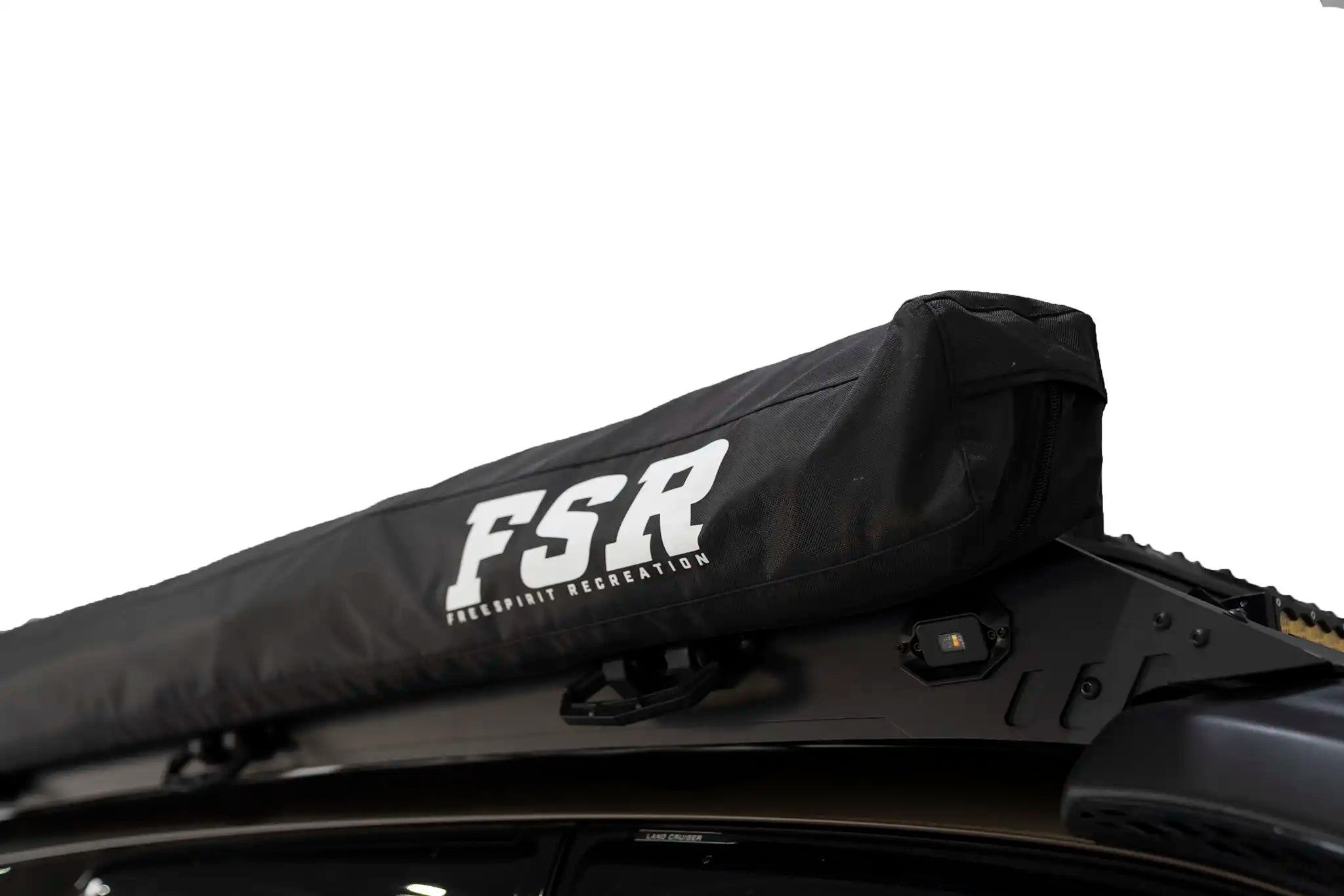 Freespirit Recreation 180 Awning V2 attached to a vehicle, showcasing durable fabric and extended coverage in outdoor setting.