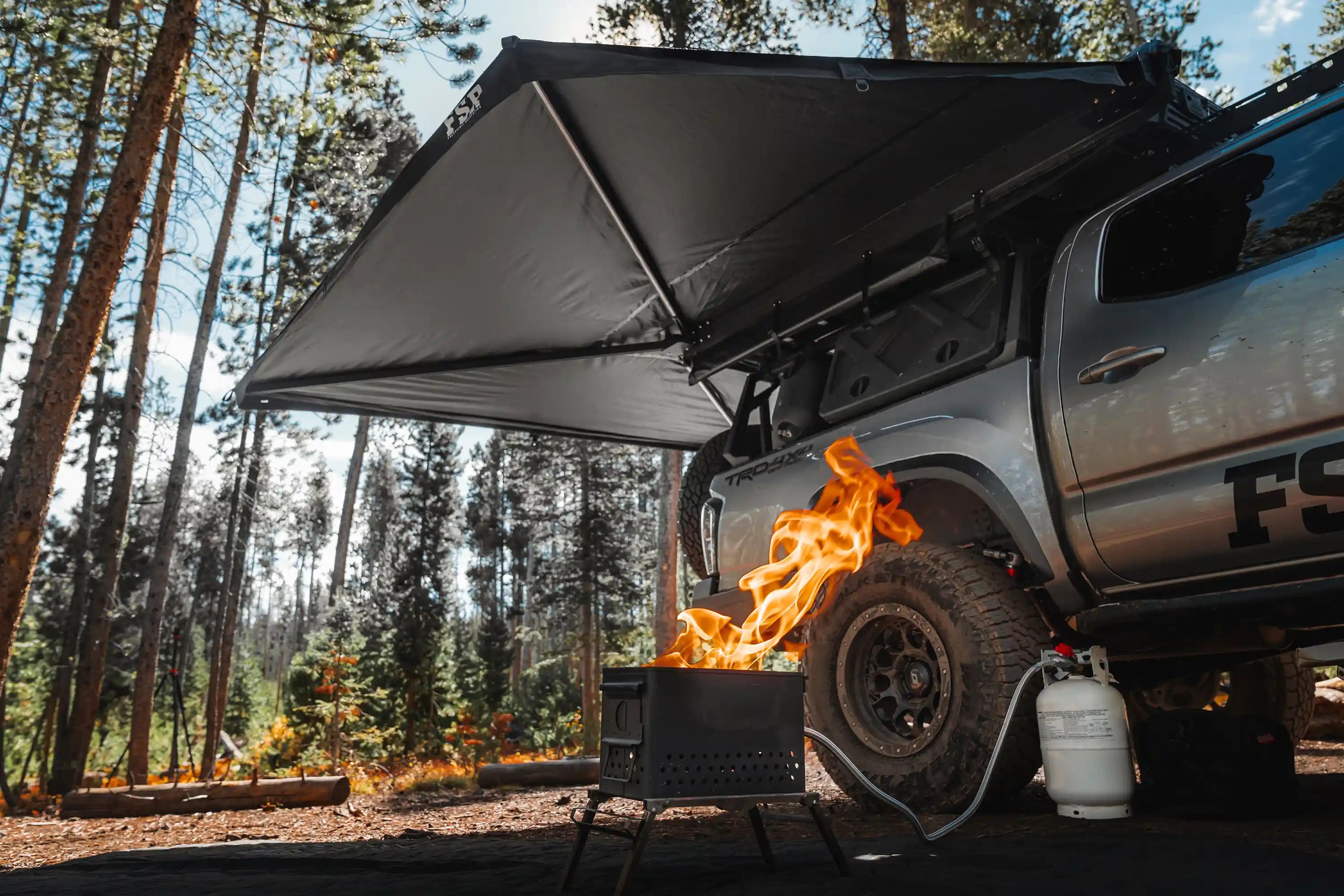 Freespirit Recreation 270 Awning V2 setup over a campsite, providing shade and shelter for outdoor activities.